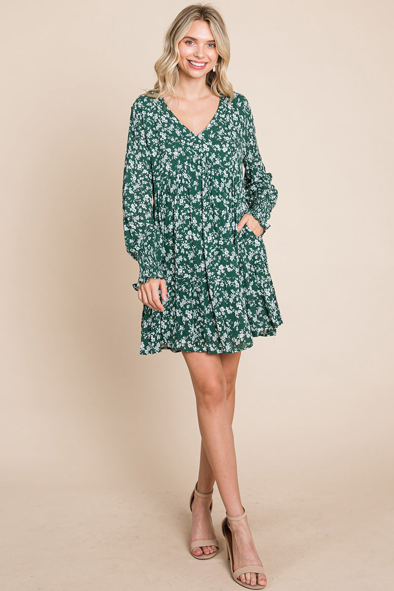 A stylish V neck floral printed long sleeve pleated dress, featuring smocked sleeves and a mini length, perfect for various occasions.