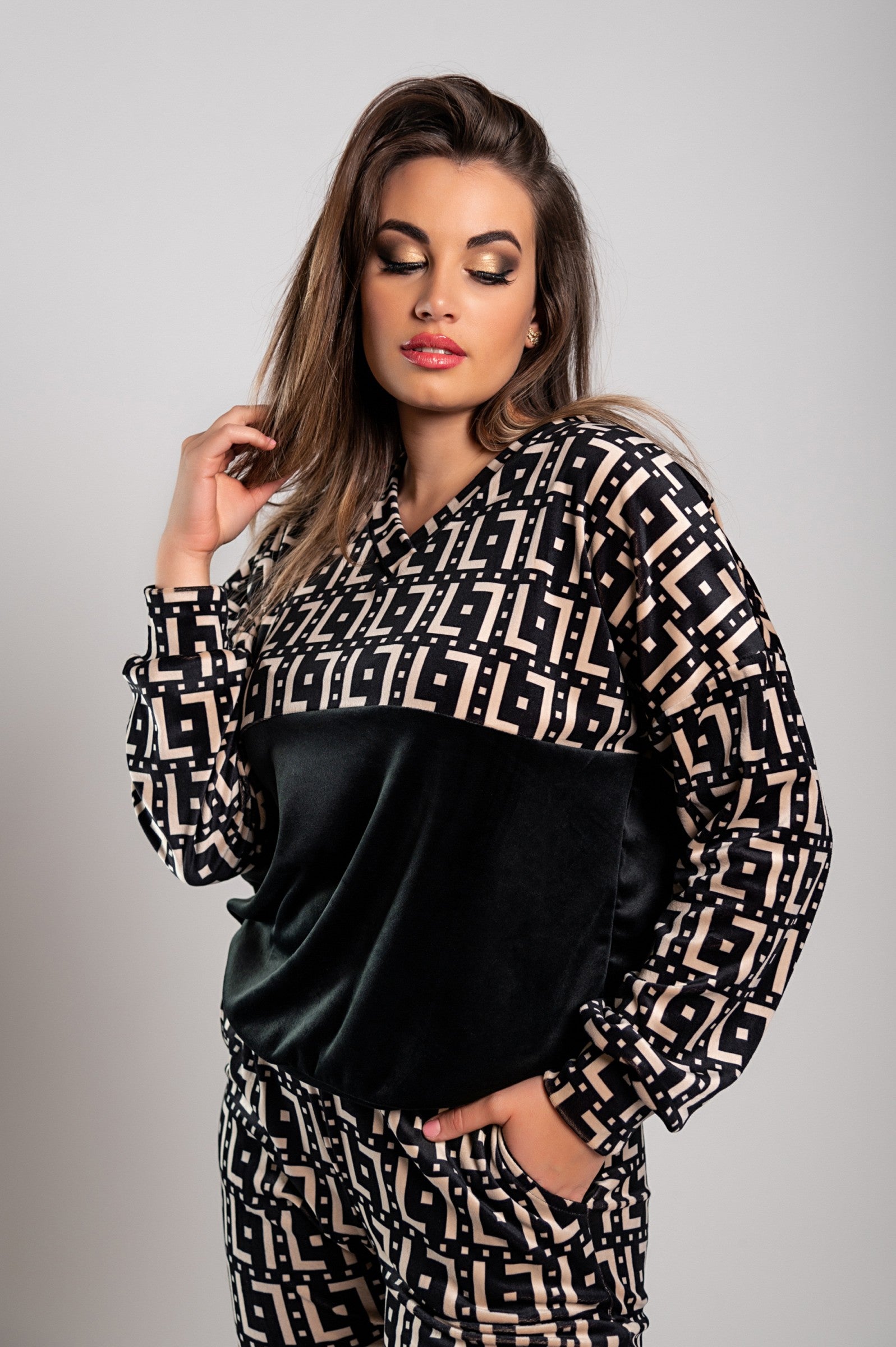 Model posing in geometric-patterned outfit.