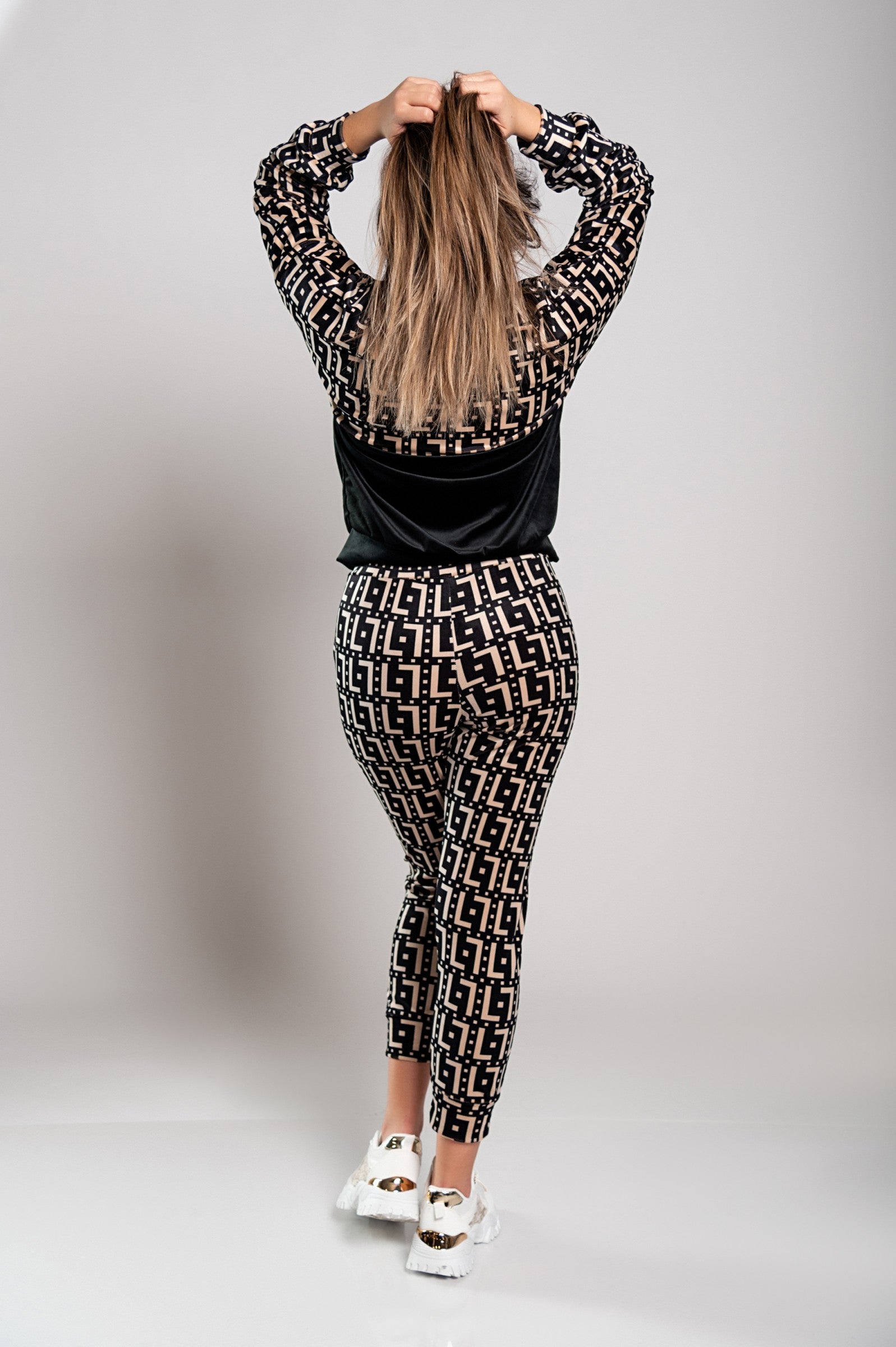 Person in patterned outfit, back view.