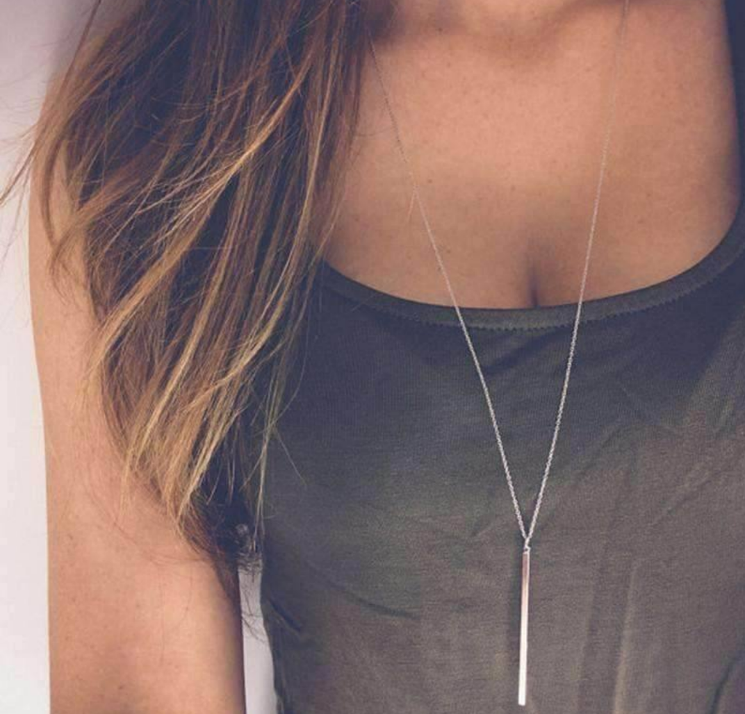 A stylish Vertical Bar Necklace featuring a sleek solid bar pendant on a long chain, perfect for layering.