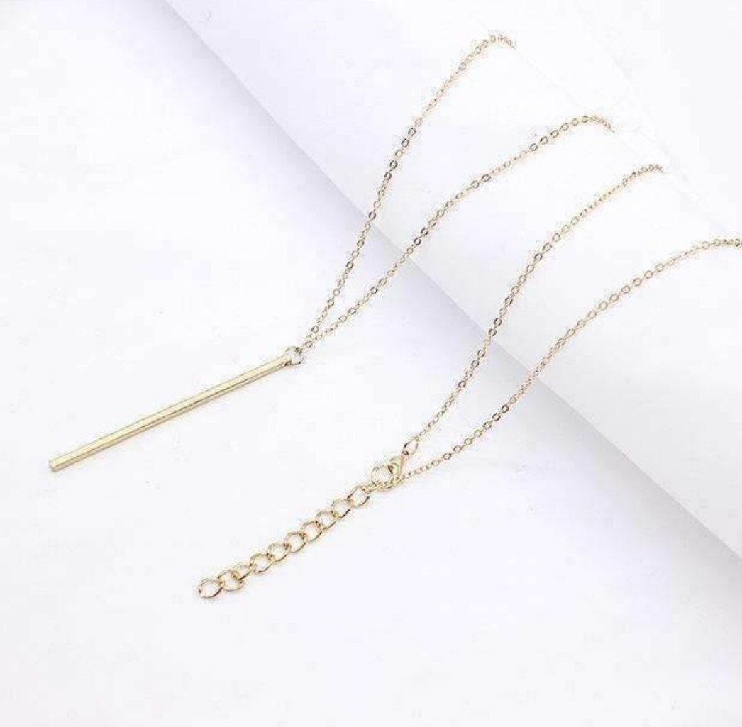 A stylish Vertical Bar Necklace featuring a sleek solid bar pendant on a long chain, perfect for layering.