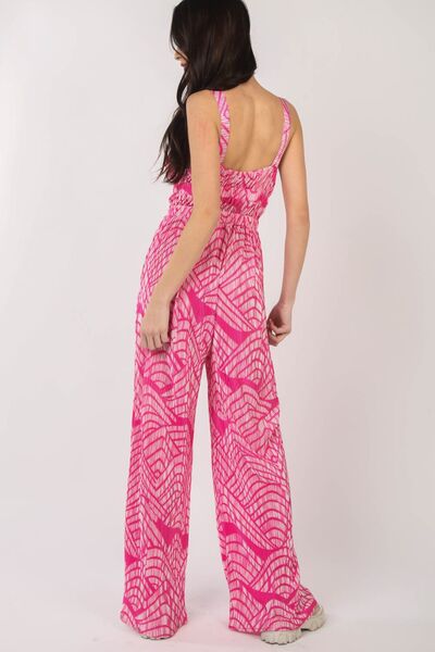 A stylish woman wearing the VERY J Printed Pleated Sleeveless Wide Leg Jumpsuit, showcasing its chic design and flattering wide-leg cut.