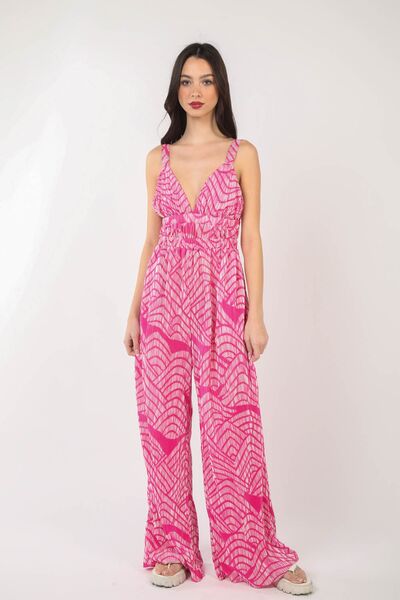 A stylish woman wearing the VERY J Printed Pleated Sleeveless Wide Leg Jumpsuit, showcasing its chic design and flattering wide-leg cut.