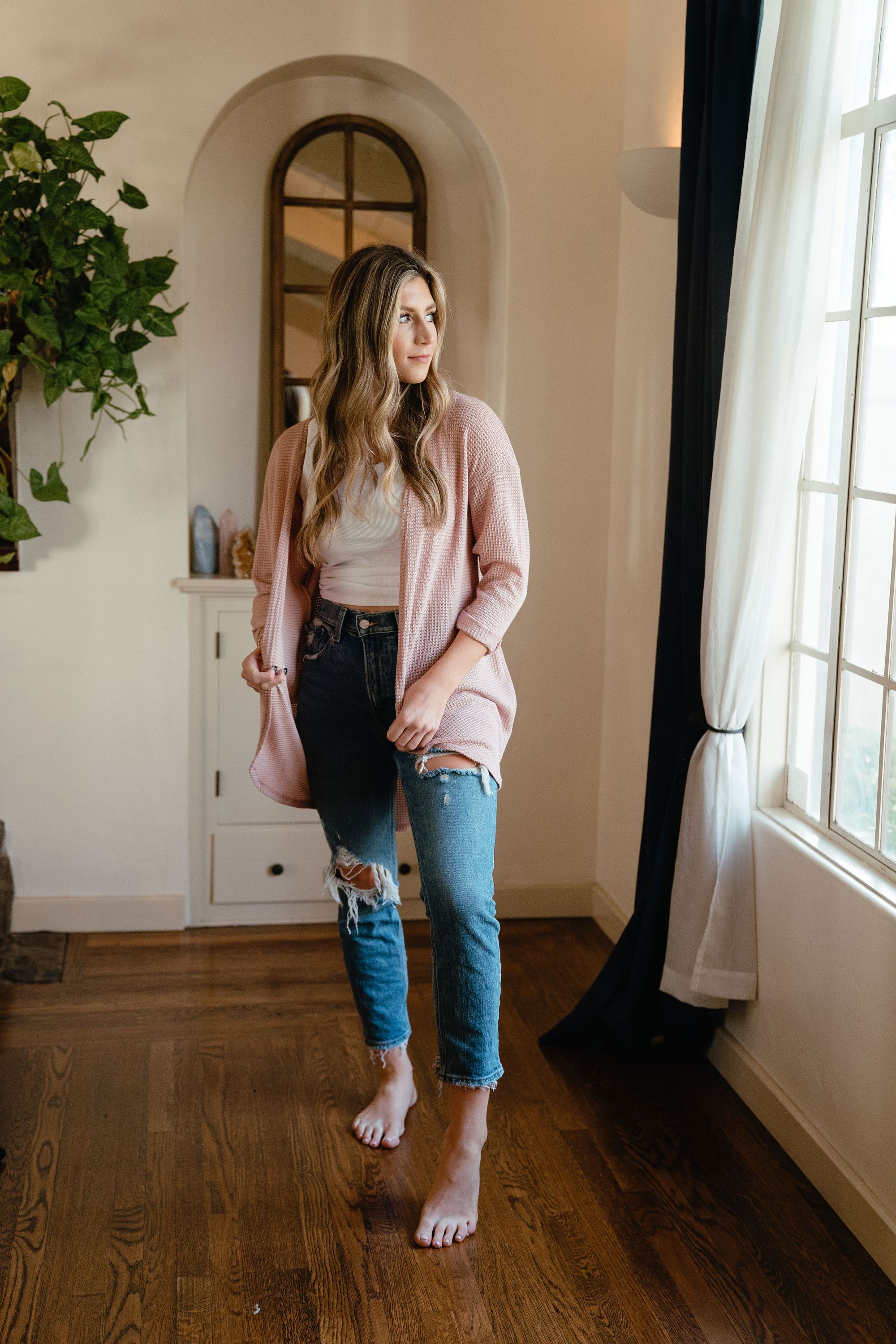 A stylish pink waffle cardigan displayed on a mannequin, showcasing its lightweight texture and versatile design.