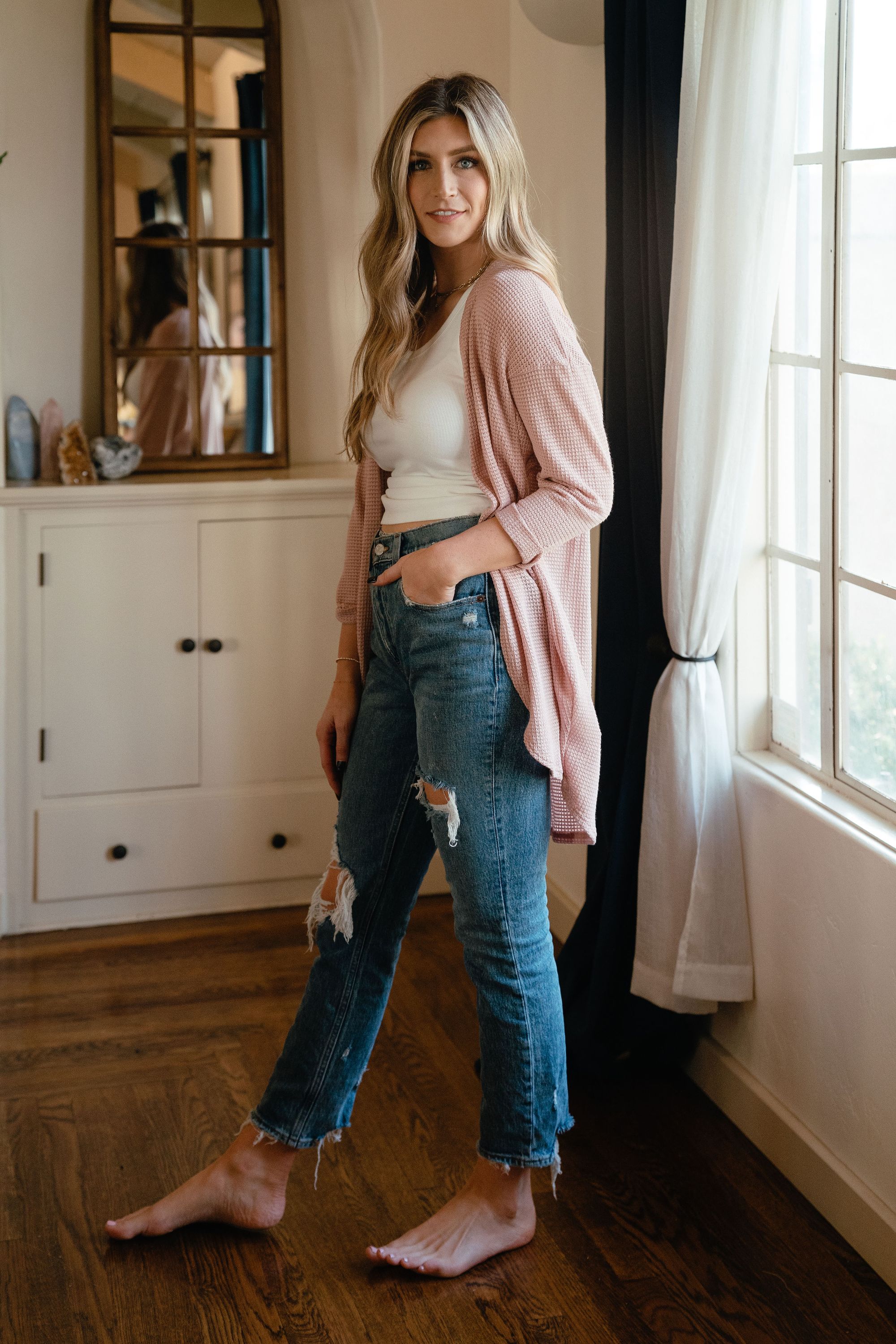 A stylish pink waffle cardigan displayed on a mannequin, showcasing its lightweight texture and versatile design.