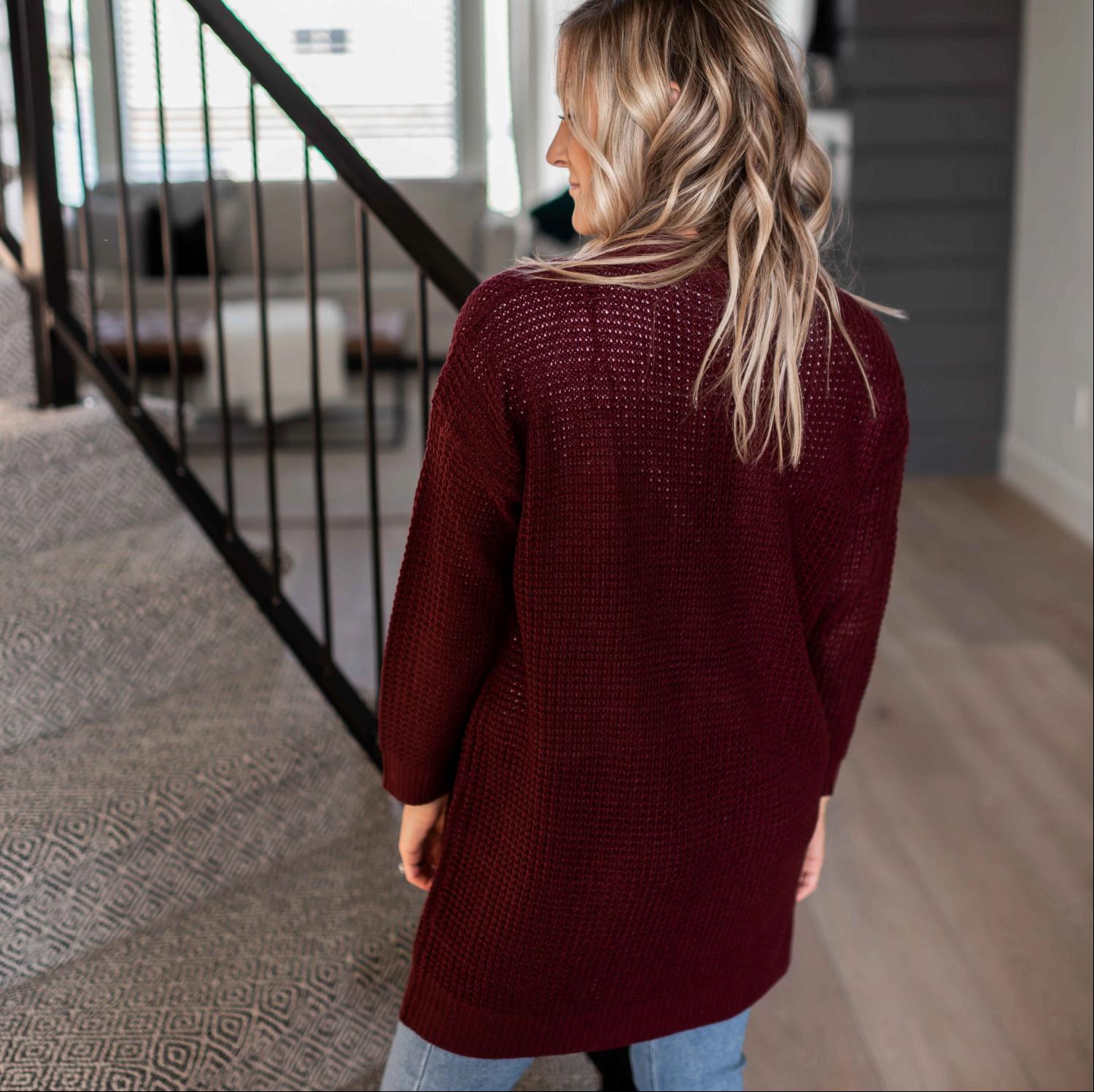 A stylish waffle knit pocketed long sleeve cardigan sweater in a soft fabric, featuring an open front and two large pockets, perfect for fall layering.