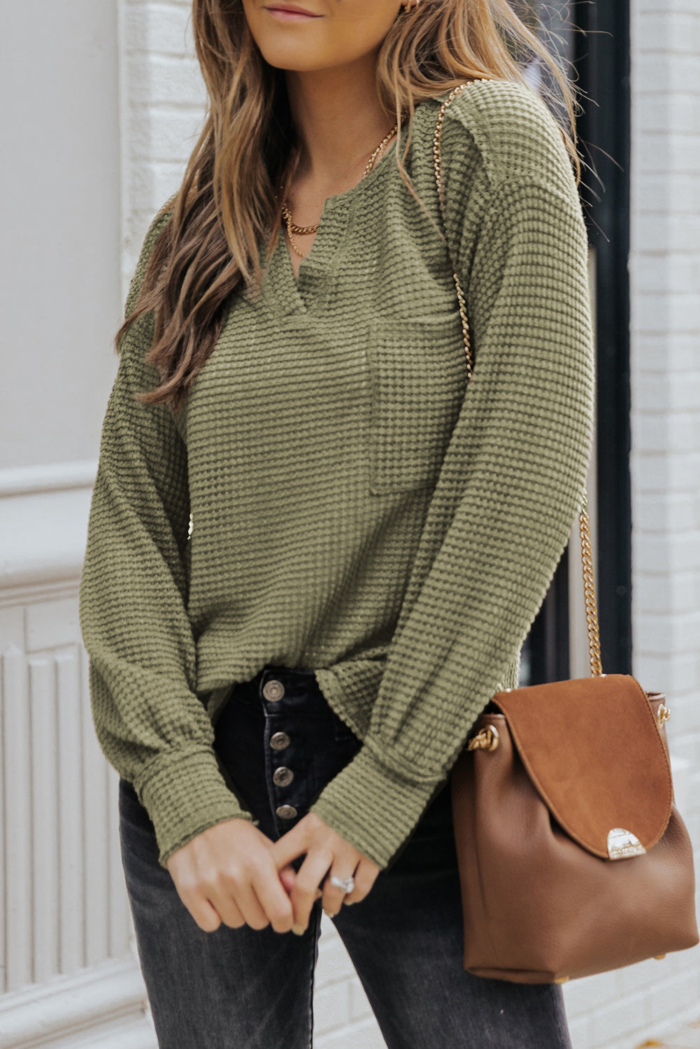 Waffle-Knit Notched High-Low Top in solid color with pockets and long sleeves, showcasing a chic and comfortable design.