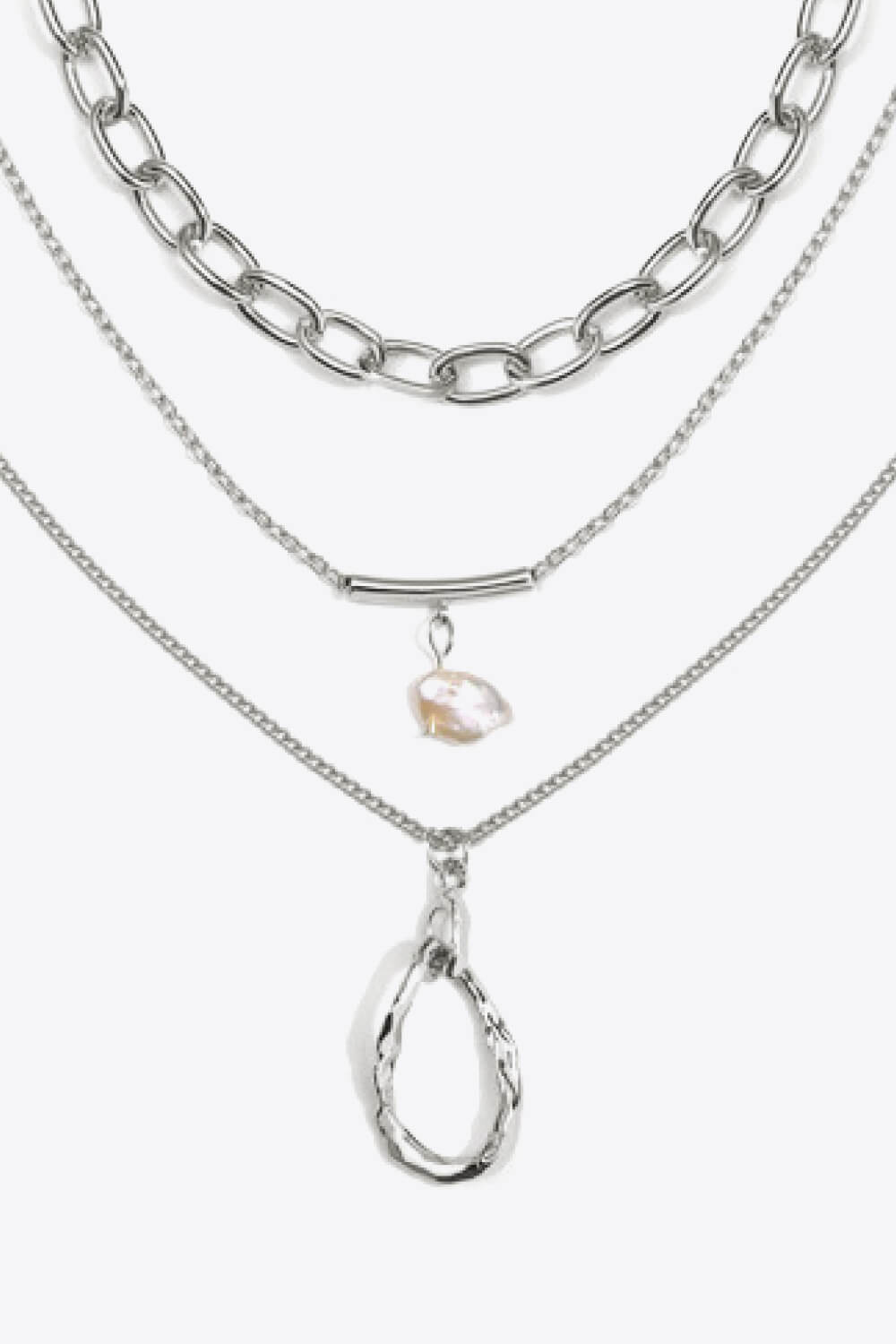 A stylish triple-layered necklace featuring stainless steel, 18k gold plating, and a freshwater pearl, displayed in a studio setting.