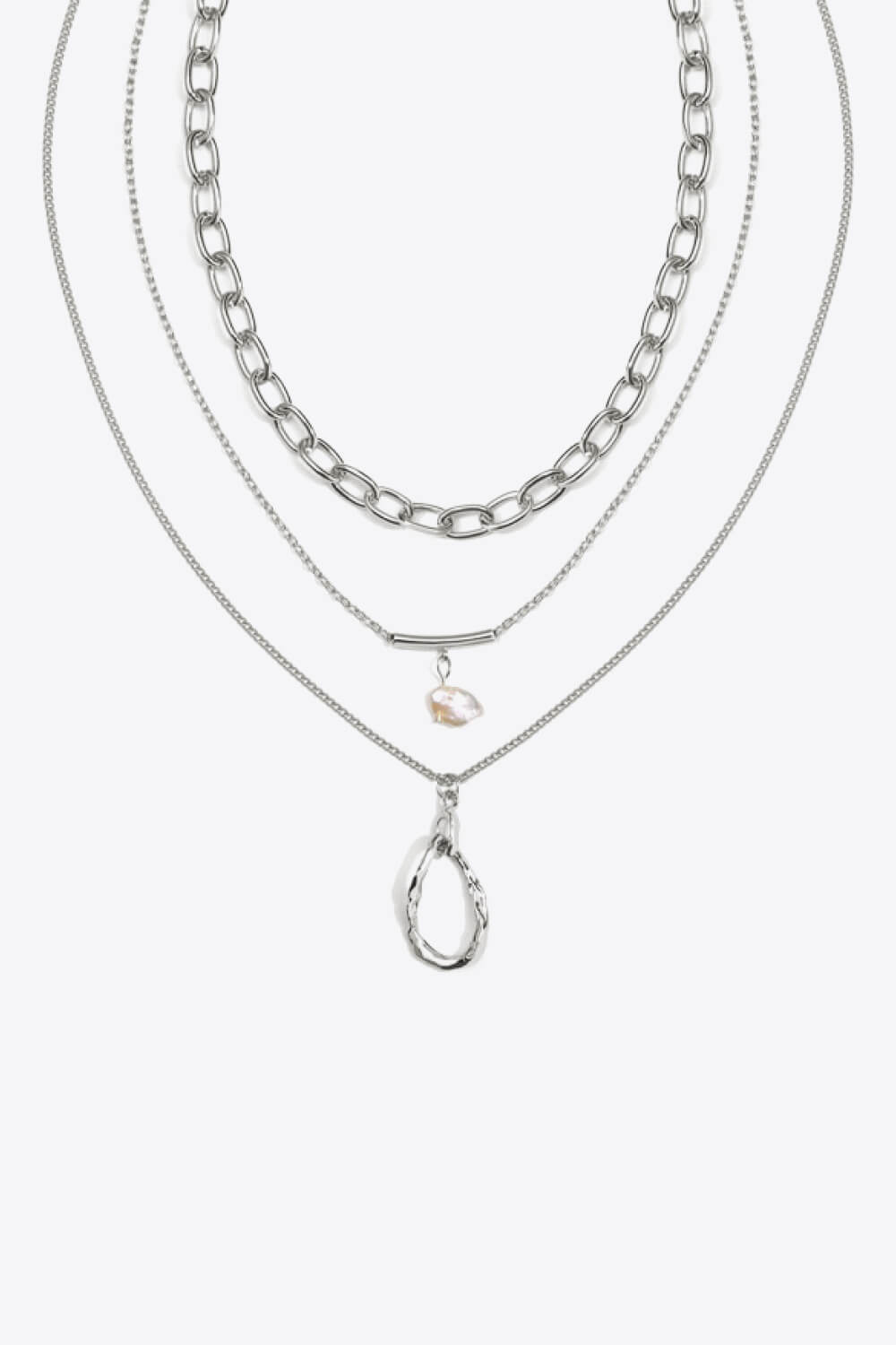 A stylish triple-layered necklace featuring stainless steel, 18k gold plating, and a freshwater pearl, displayed in a studio setting.