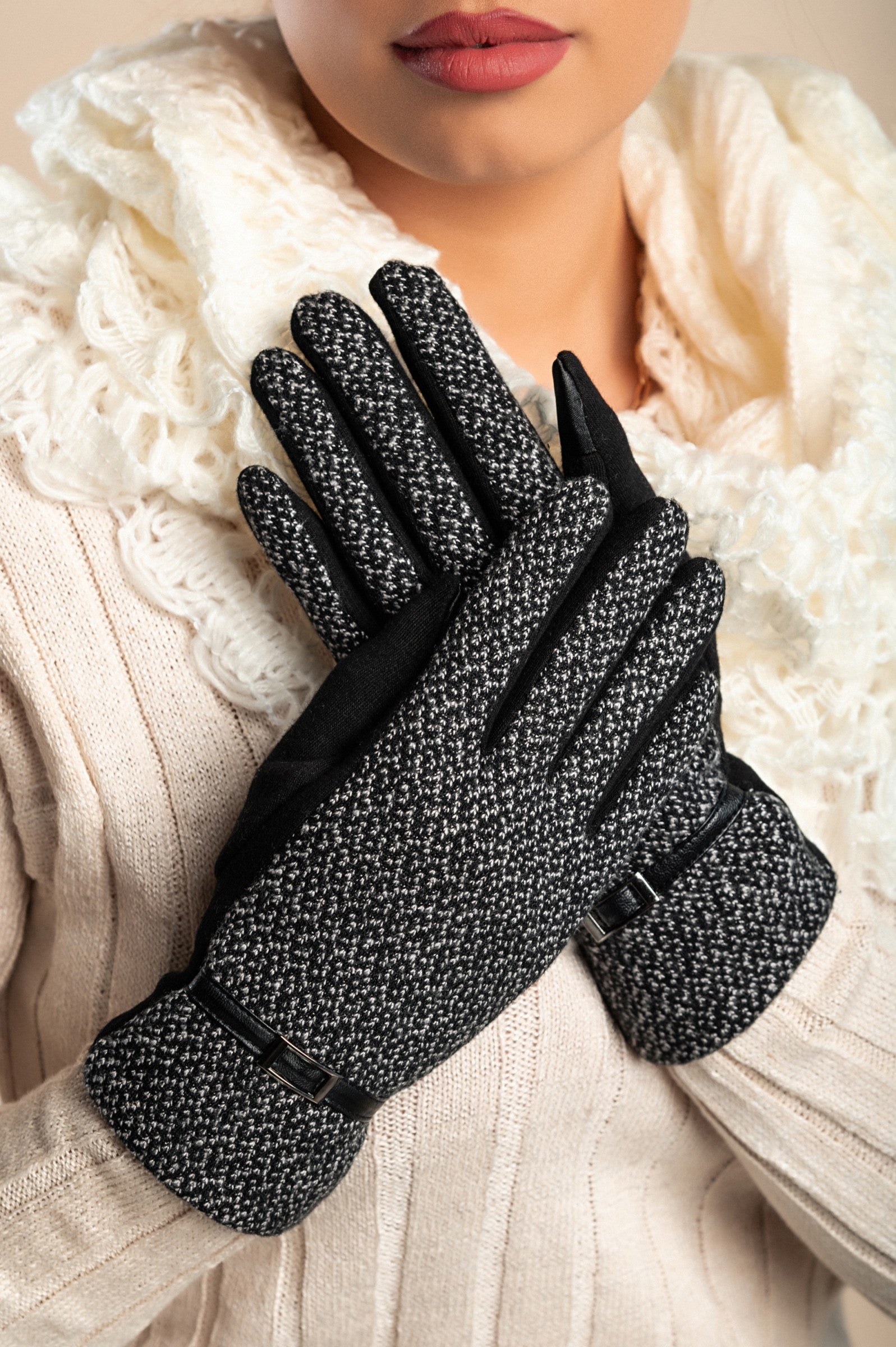 A pair of black warm gloves with a decorative strap on the wrist, padded for extra warmth and comfort.