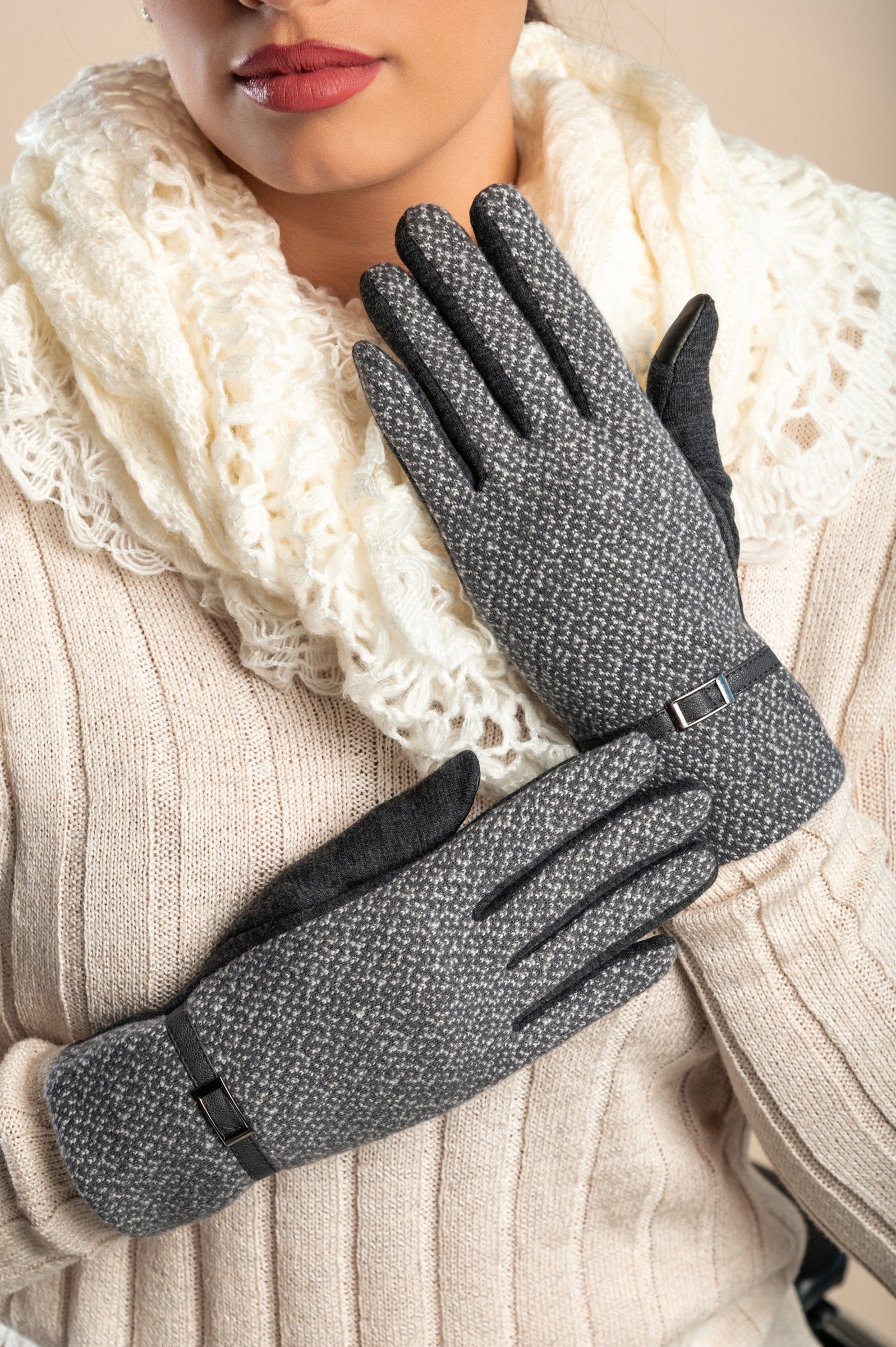 A pair of soft gray warm gloves featuring a decorative strap on the wrist, perfect for winter wear.