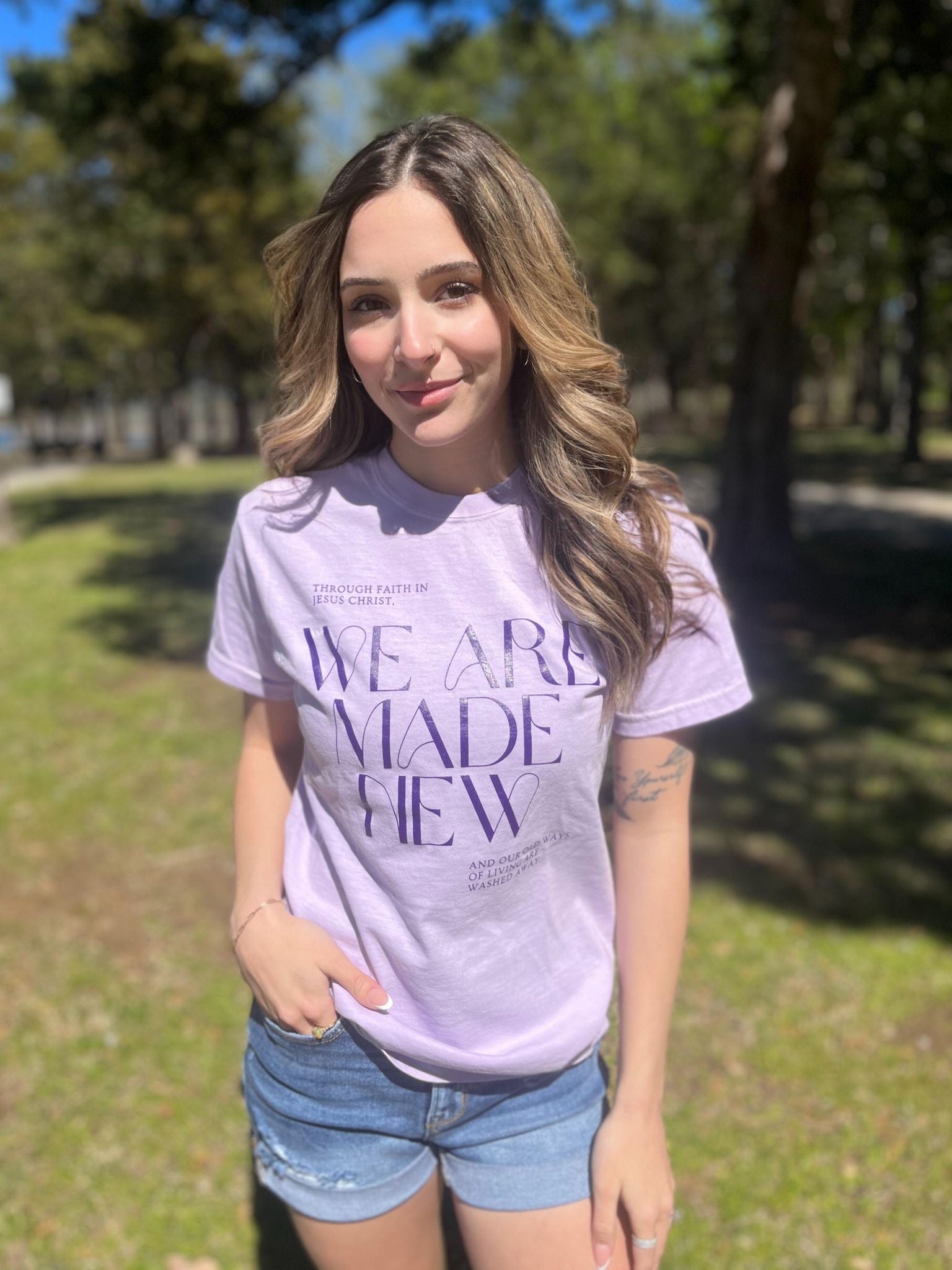 A stylish monochrome purple tee with the text 'We Are Made New' printed on it, showcasing a comfortable fit.