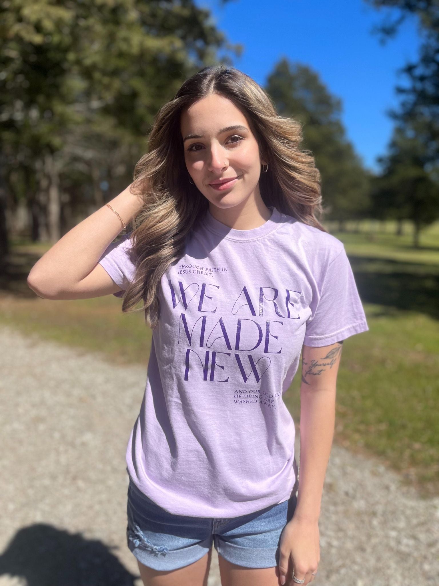 A stylish monochrome purple tee with the text 'We Are Made New' printed on it, showcasing a comfortable fit.