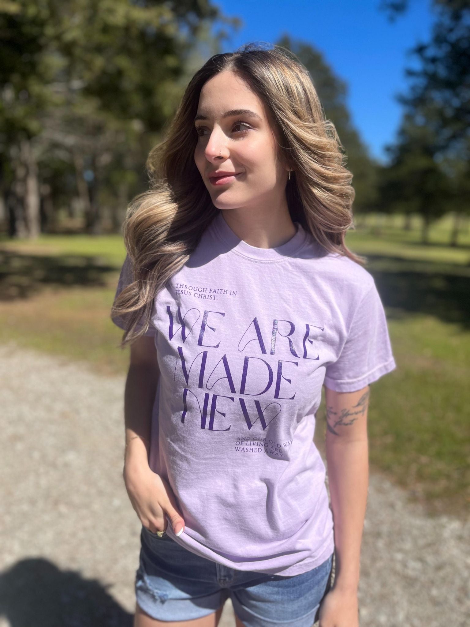 A stylish monochrome purple tee with the text 'We Are Made New' printed on it, showcasing a comfortable fit.