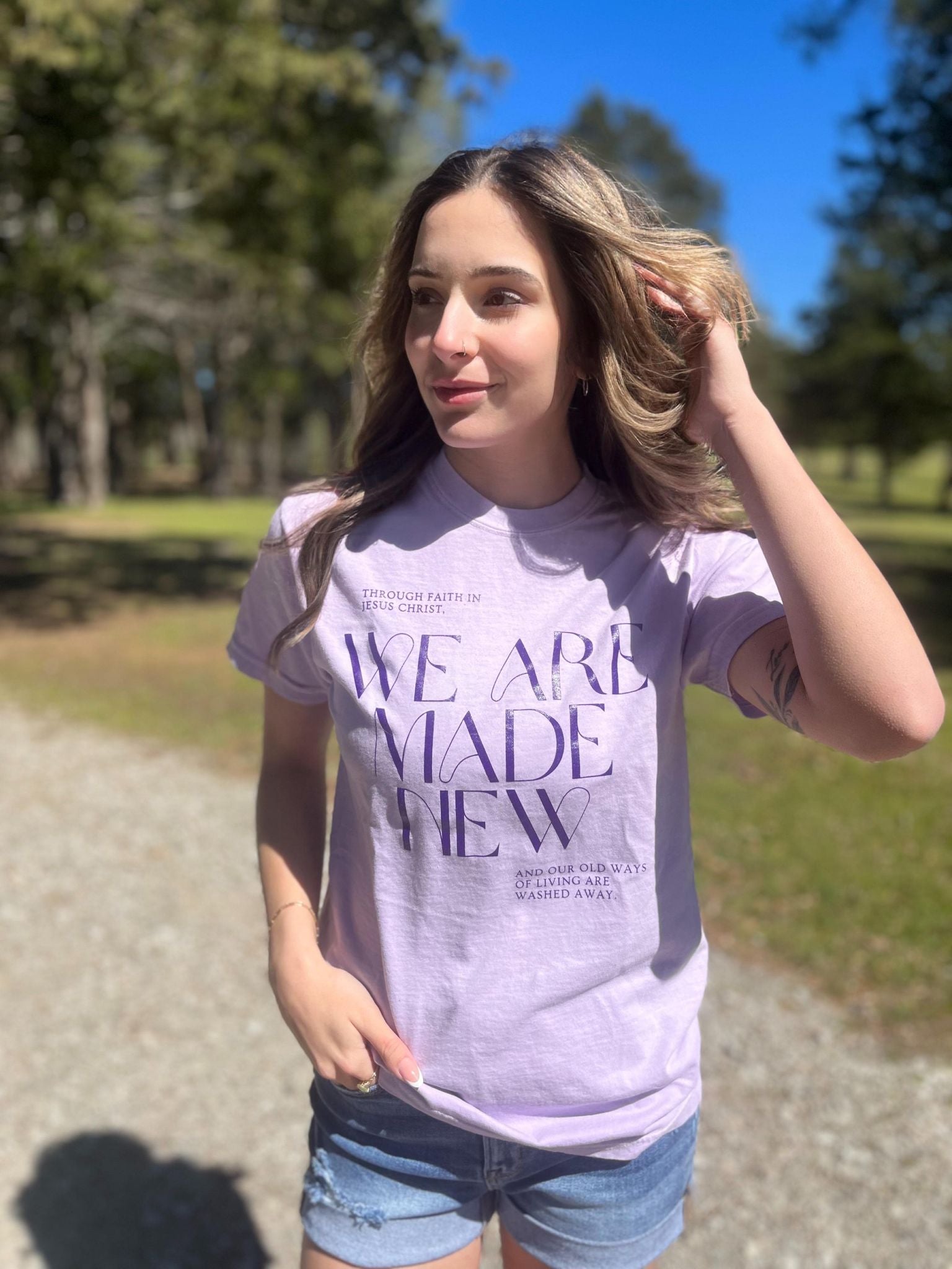 A stylish monochrome purple tee with the text 'We Are Made New' printed on it, showcasing a comfortable fit.