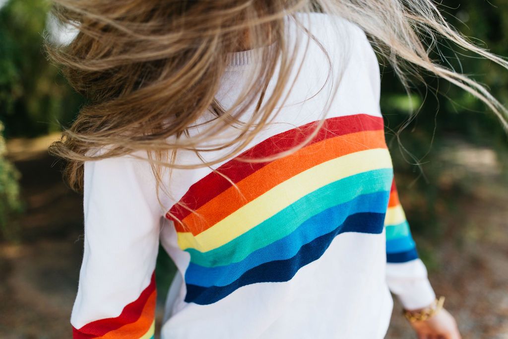 A cozy White Rainbow Sweater featuring a soft fabric blend, perfect for winter layering and stylish outfits.