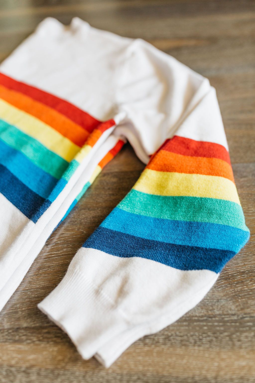 A cozy White Rainbow Sweater featuring a soft fabric blend, perfect for winter layering and stylish outfits.