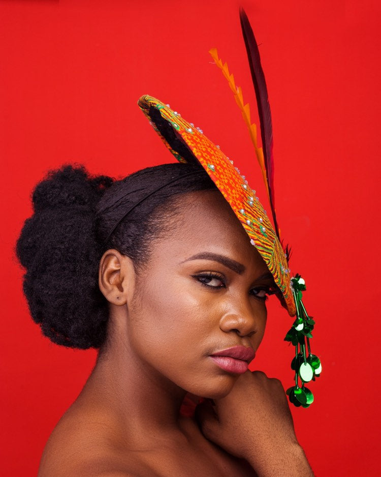 A stylish wide brim hat made from vibrant Ankara fabric, featuring elegant embellishments and Swarovski crystals, perfect for any occasion.