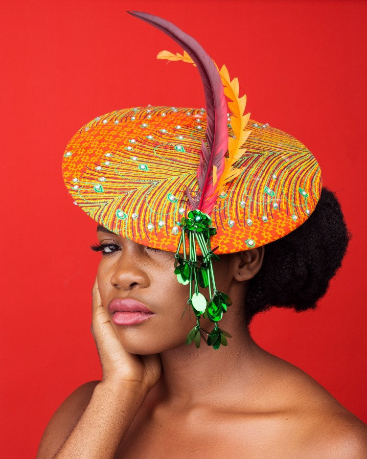 A stylish wide brim hat made from vibrant Ankara fabric, featuring elegant embellishments and Swarovski crystals, perfect for any occasion.