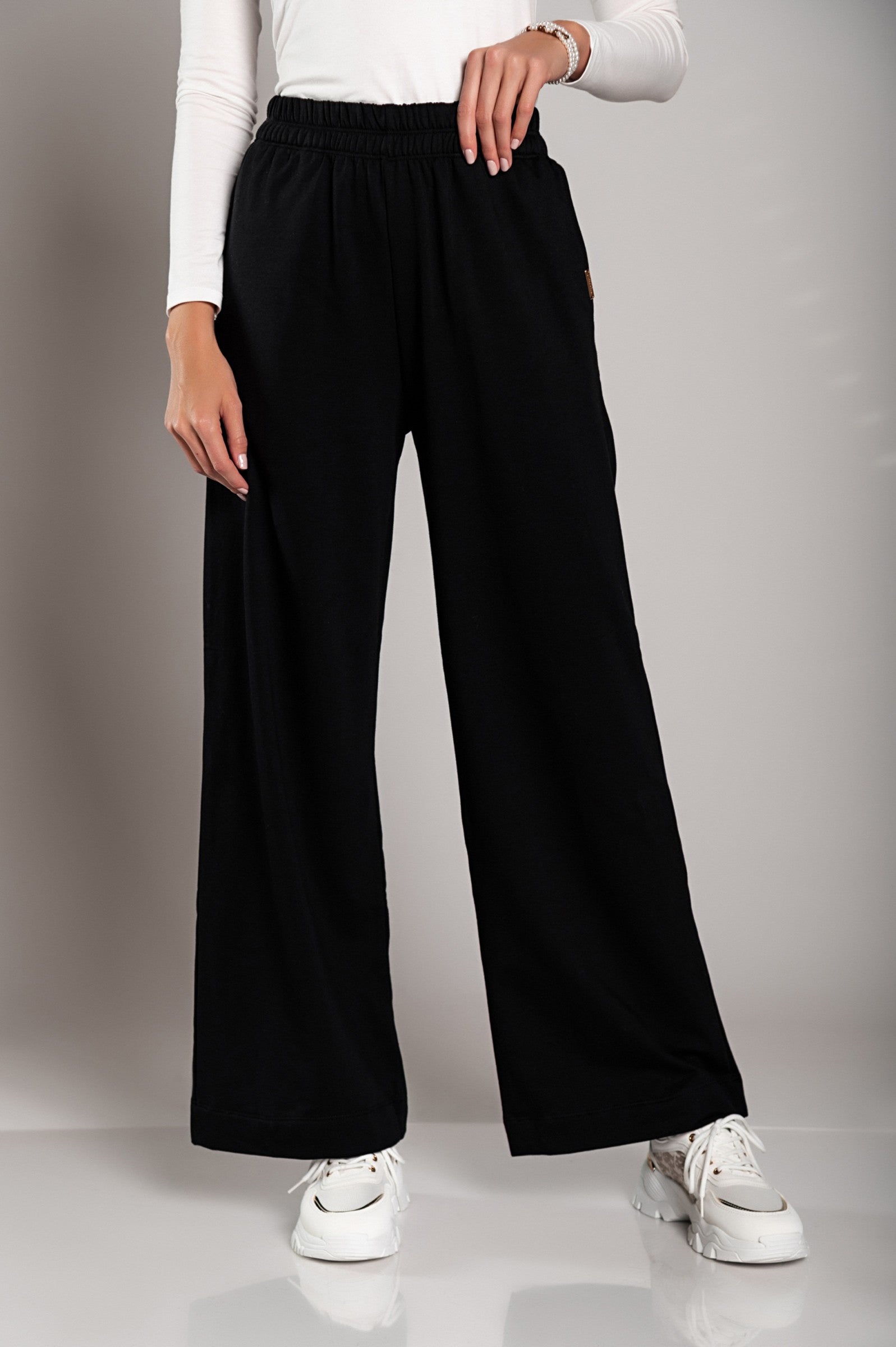 Wide leg cotton sports trousers in black, featuring an elastic waist and side pockets, made from sustainable materials.