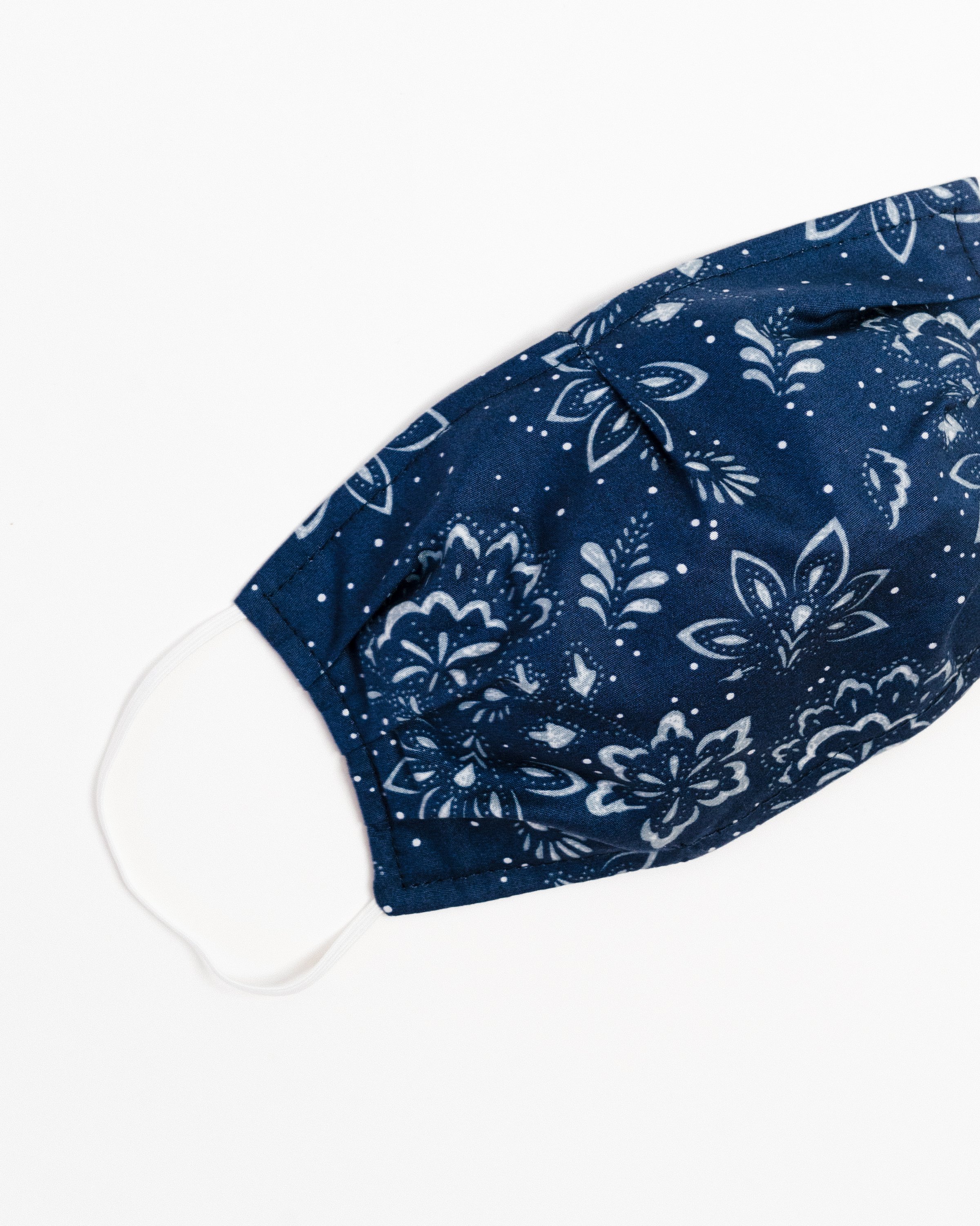 A stylish winter floral face mask made of breathable cotton, featuring a double-layered design and elastic ear straps for comfort.