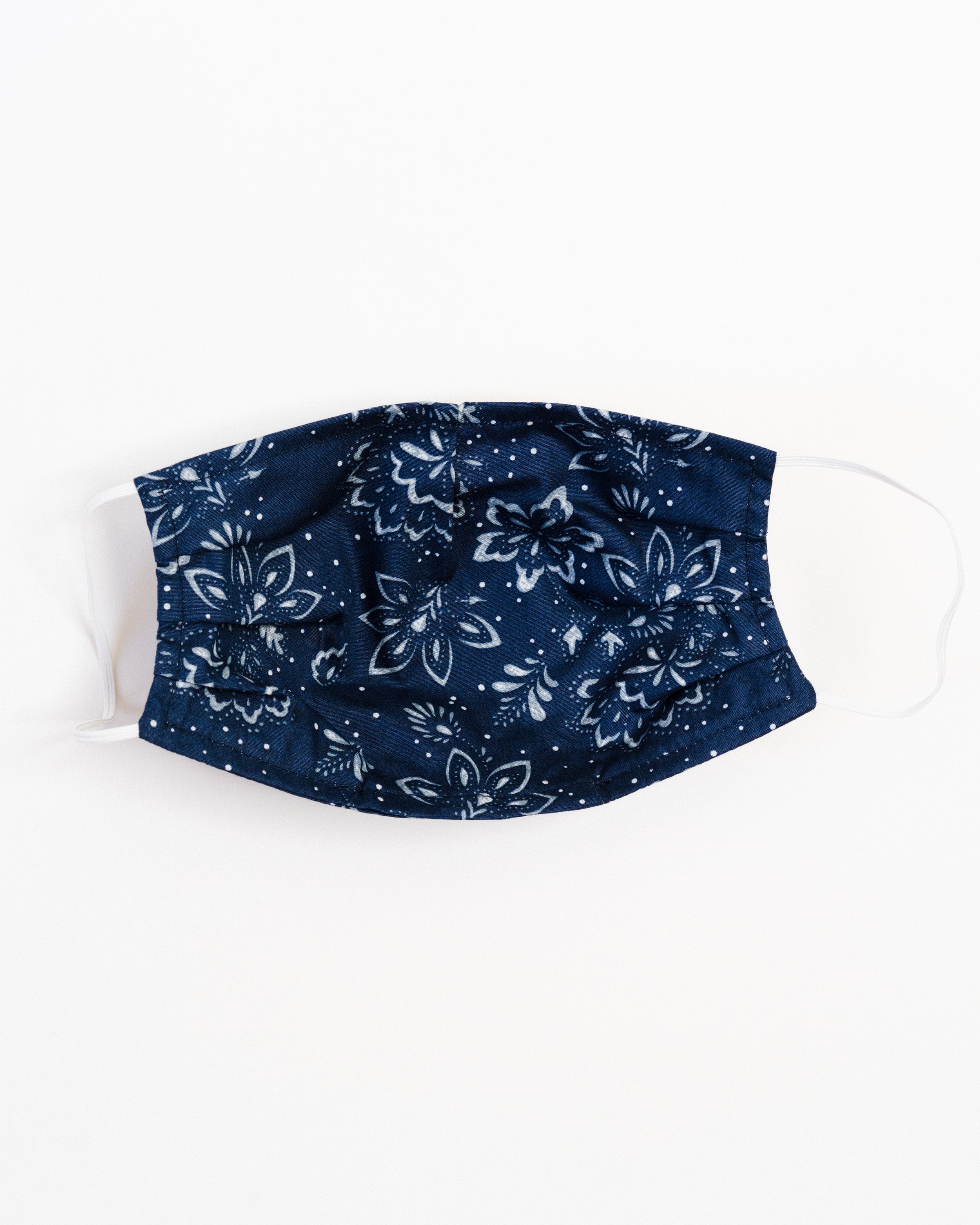 A stylish winter floral face mask made of breathable cotton, featuring a double-layered design and elastic ear straps for comfort.