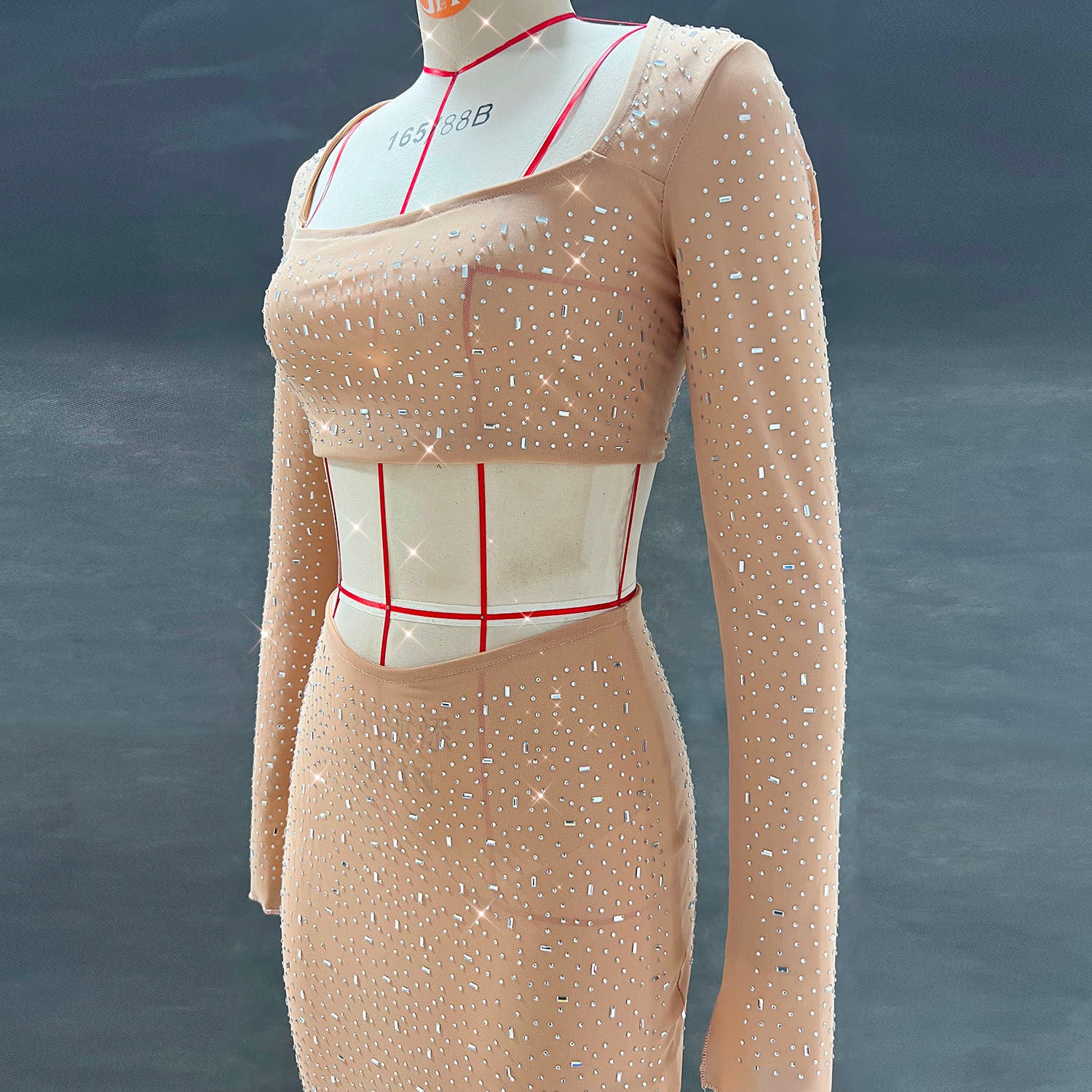 A stylish women's outfit featuring a sexy rhinestone crop top with long sleeves and a low-rise midi mermaid skirt, perfect for elegant occasions.