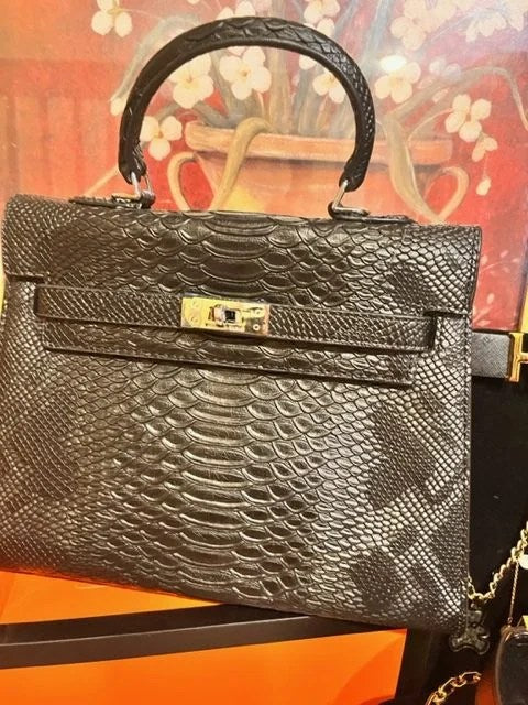 A stylish medium bag made from genuine alligator leather, featuring an open front pocket and elegant accessories like keys and a lock.