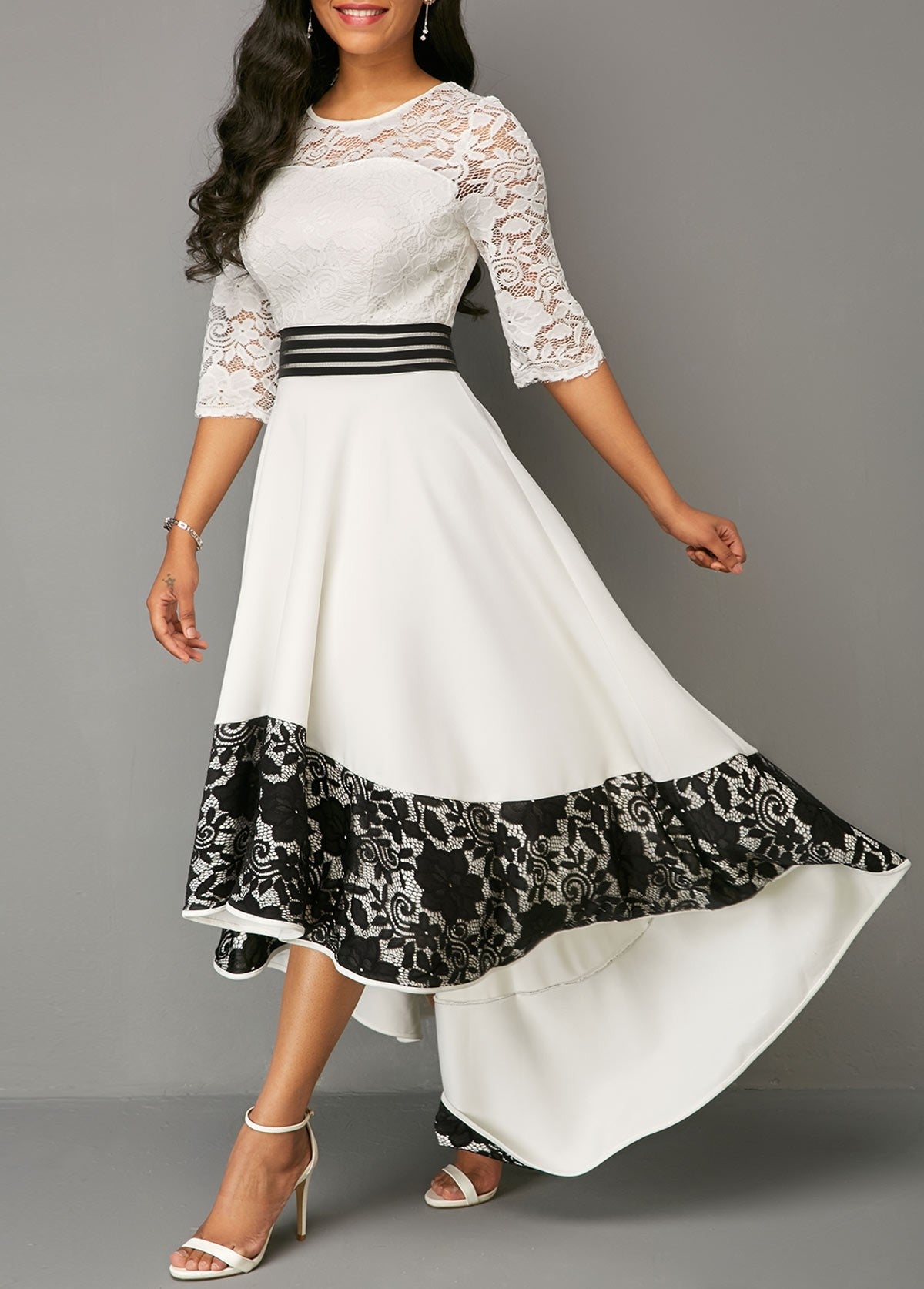 Elegant white asymmetrical dress with lace detailing, featuring 3/4 translucent sleeves and a tight waistband.