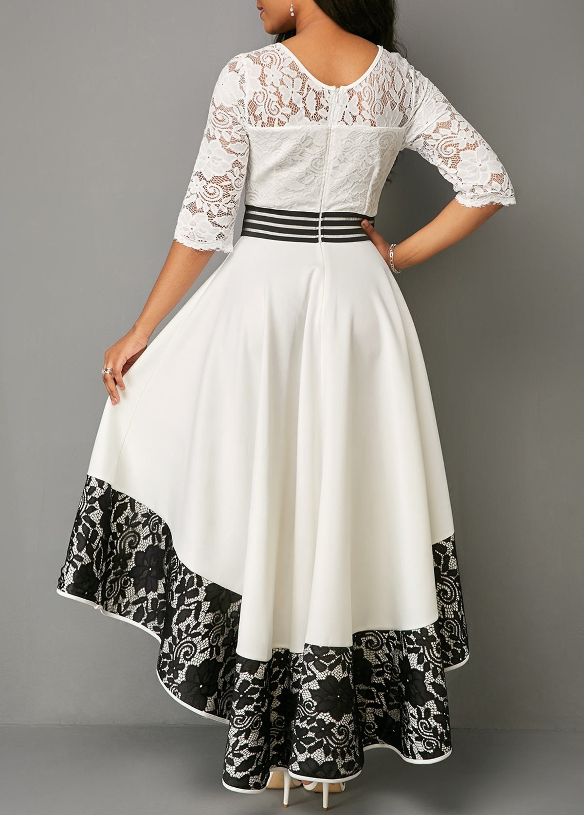 Elegant white asymmetrical dress with lace detailing, featuring 3/4 translucent sleeves and a tight waistband.