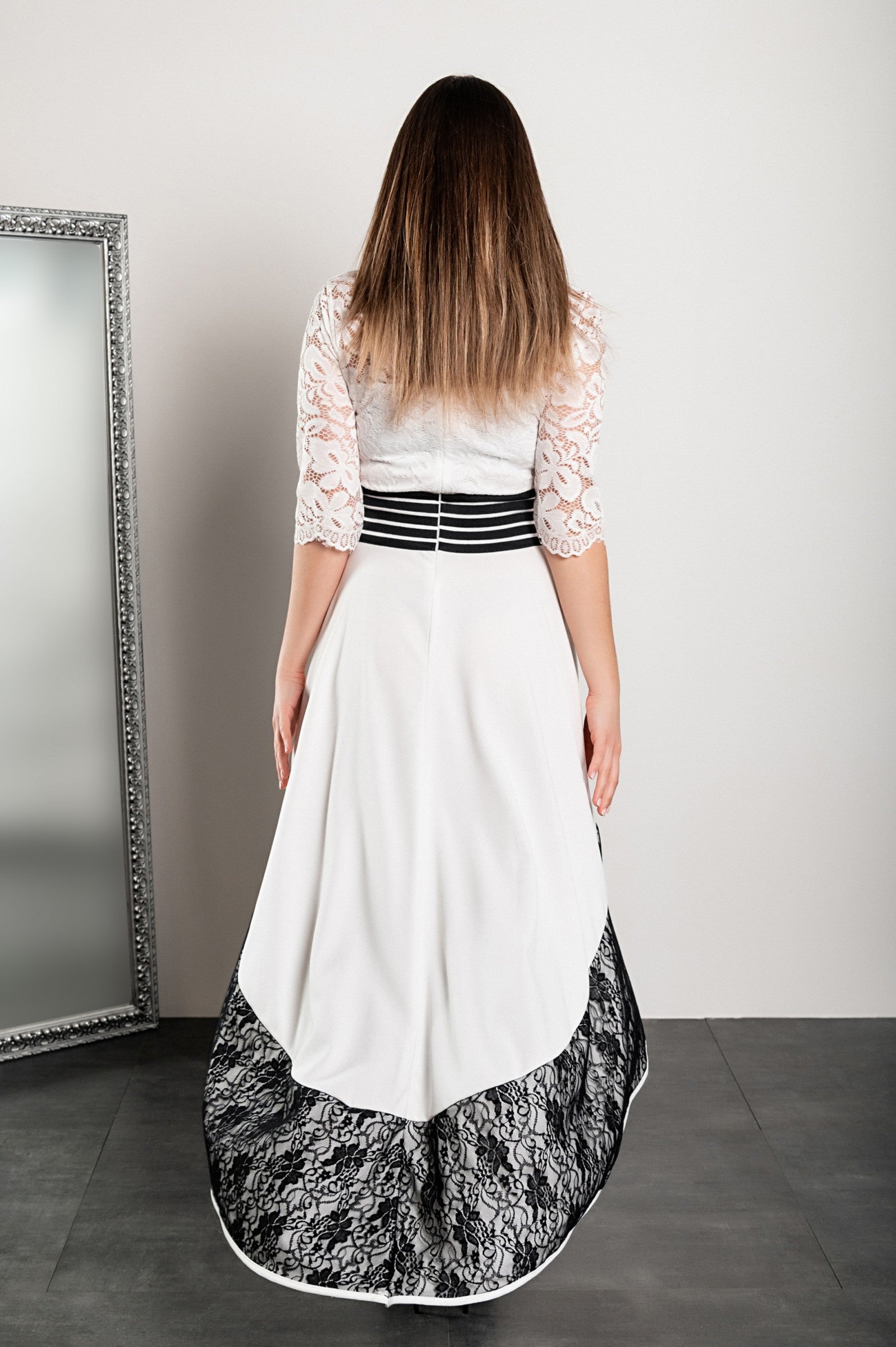 Elegant white asymmetrical dress with lace detailing, featuring 3/4 translucent sleeves and a tight waistband.