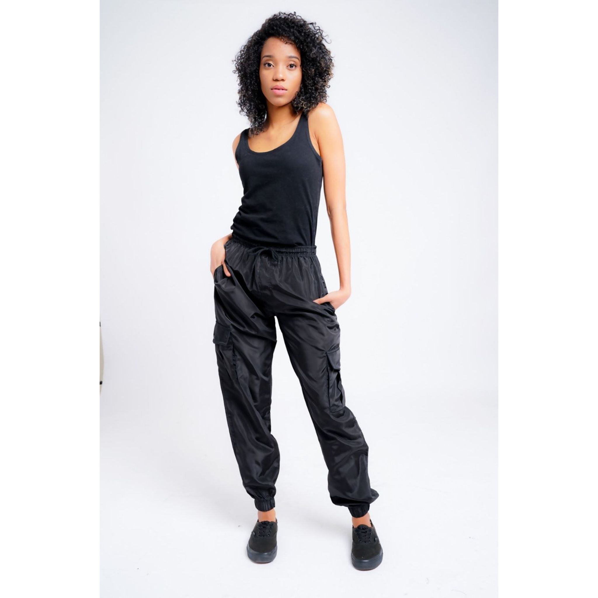 A pair of stylish women's black cargo trousers with cuffs, showcasing pockets and a modern fit.