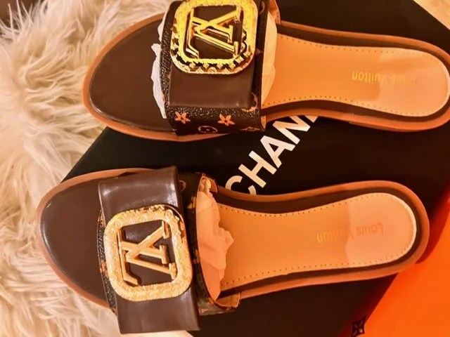 A pair of stylish Women's Fashion Flat Slide Sandals with LV design, perfect for casual wear and travel.