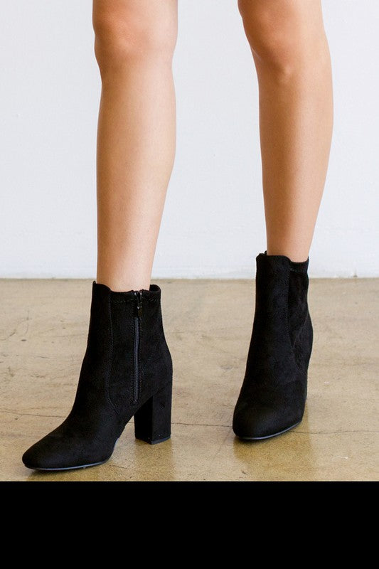 A pair of stylish women's faux suede chunky heel ankle booties with a side zipper, showcasing a modern design and comfortable block heel.