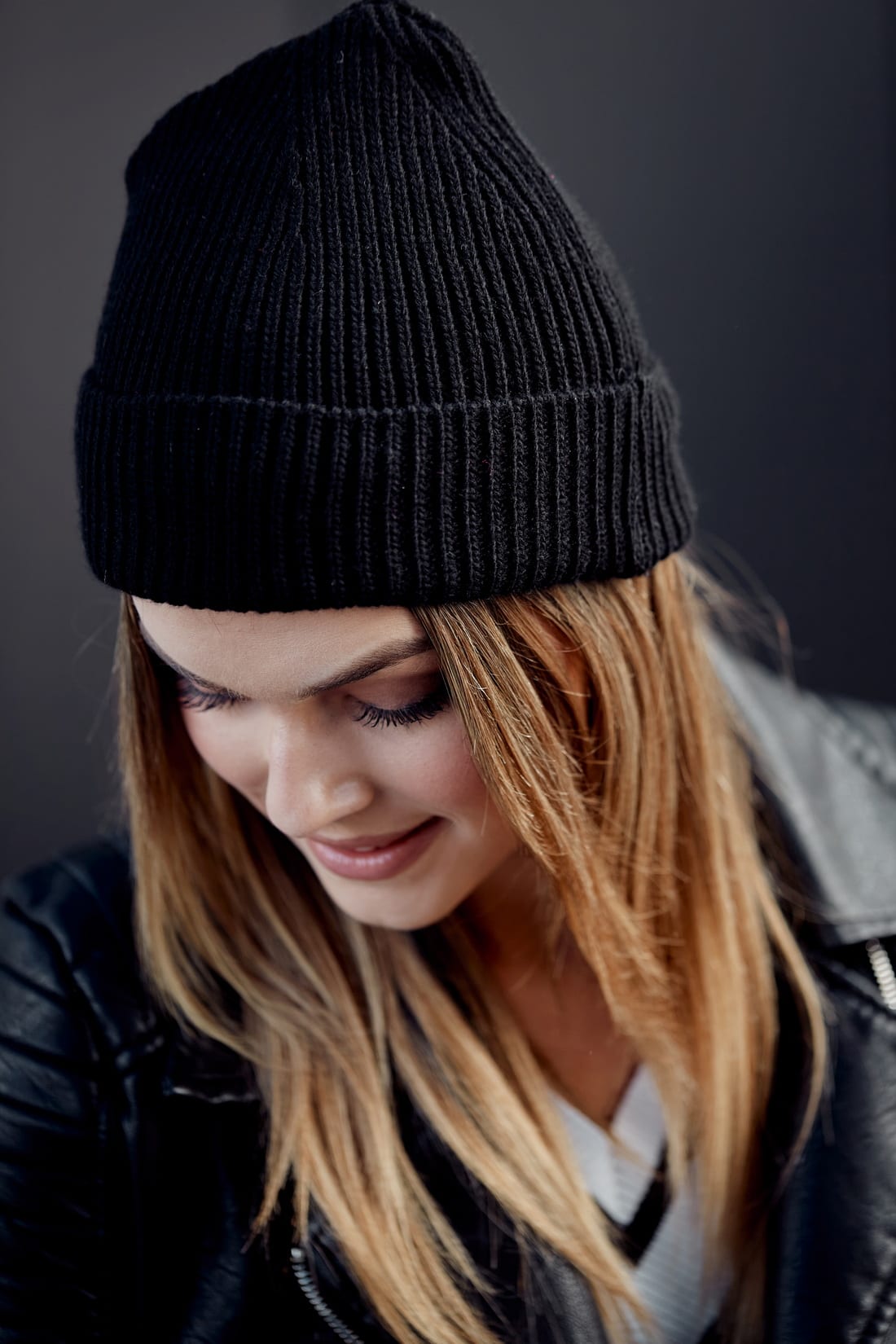 Women's black folded hat with rolled-up cuff, made from elastic sweater fabric, perfect for cold weather.