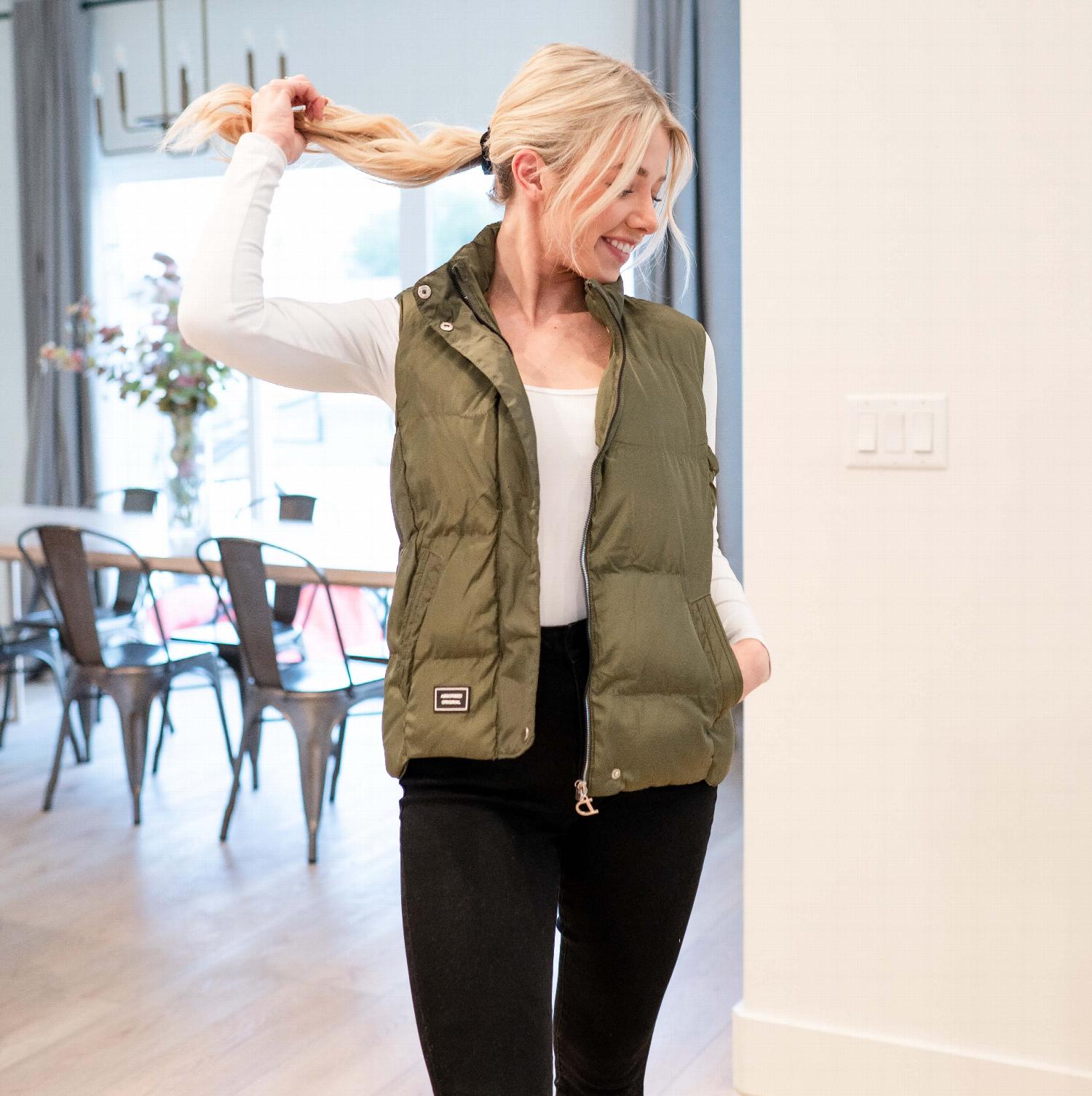 A stylish women's solid puffer jacket vest in tan color, featuring a turtleneck collar and side pockets, perfect for winter wear.