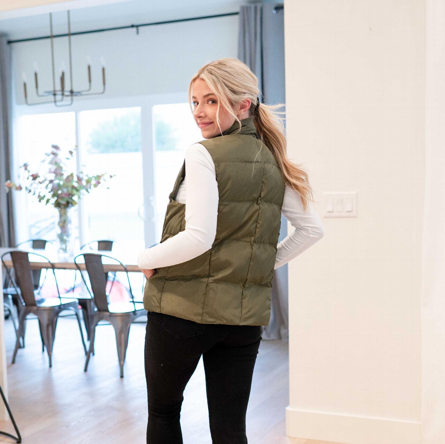 A stylish women's solid puffer jacket vest in tan color, featuring a turtleneck collar and side pockets, perfect for winter wear.