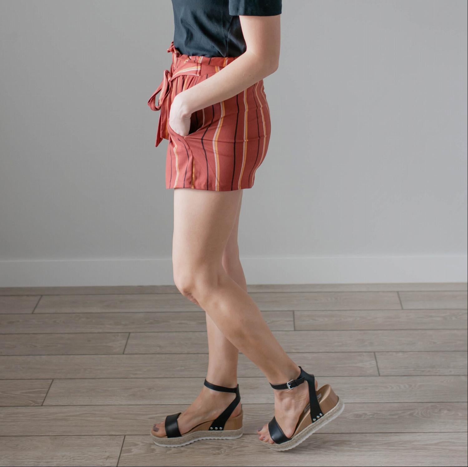 Women's high-waisted striped shorts with a waist tie, featuring a brushed stripe design and front pockets.