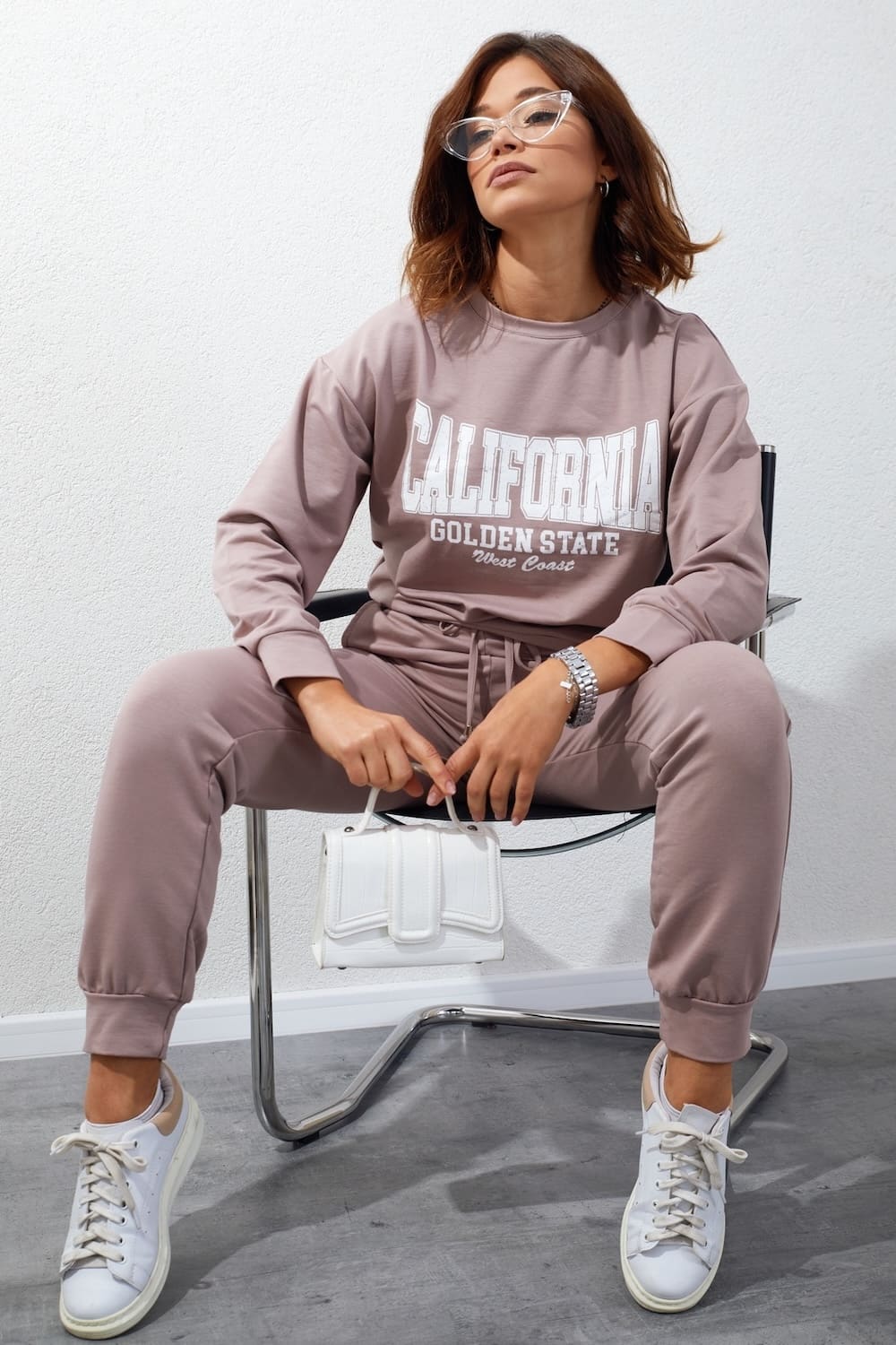 Women's tracksuit set in beige with cappuccino application, featuring long sleeves, elastic waist pants, and stylish inscriptions.