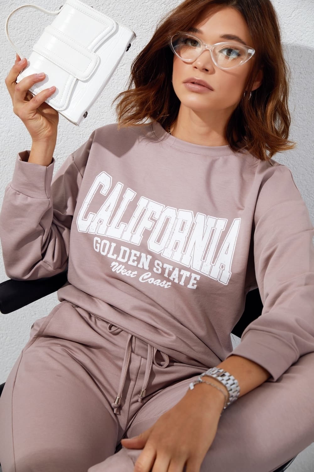 Women's tracksuit set in beige with cappuccino application, featuring long sleeves, elastic waist pants, and stylish inscriptions.