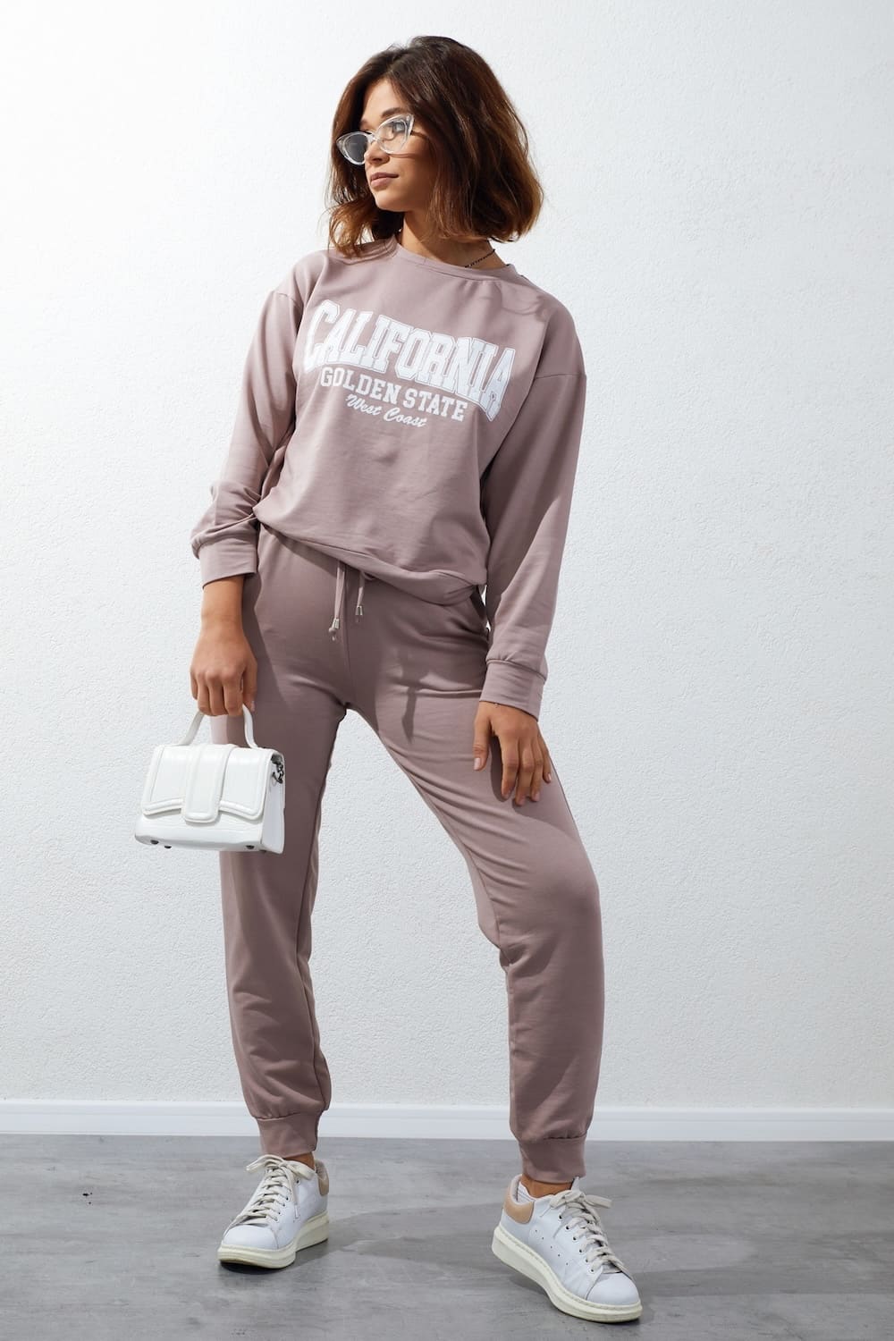 Women's tracksuit set in beige with cappuccino application, featuring long sleeves, elastic waist pants, and stylish inscriptions.