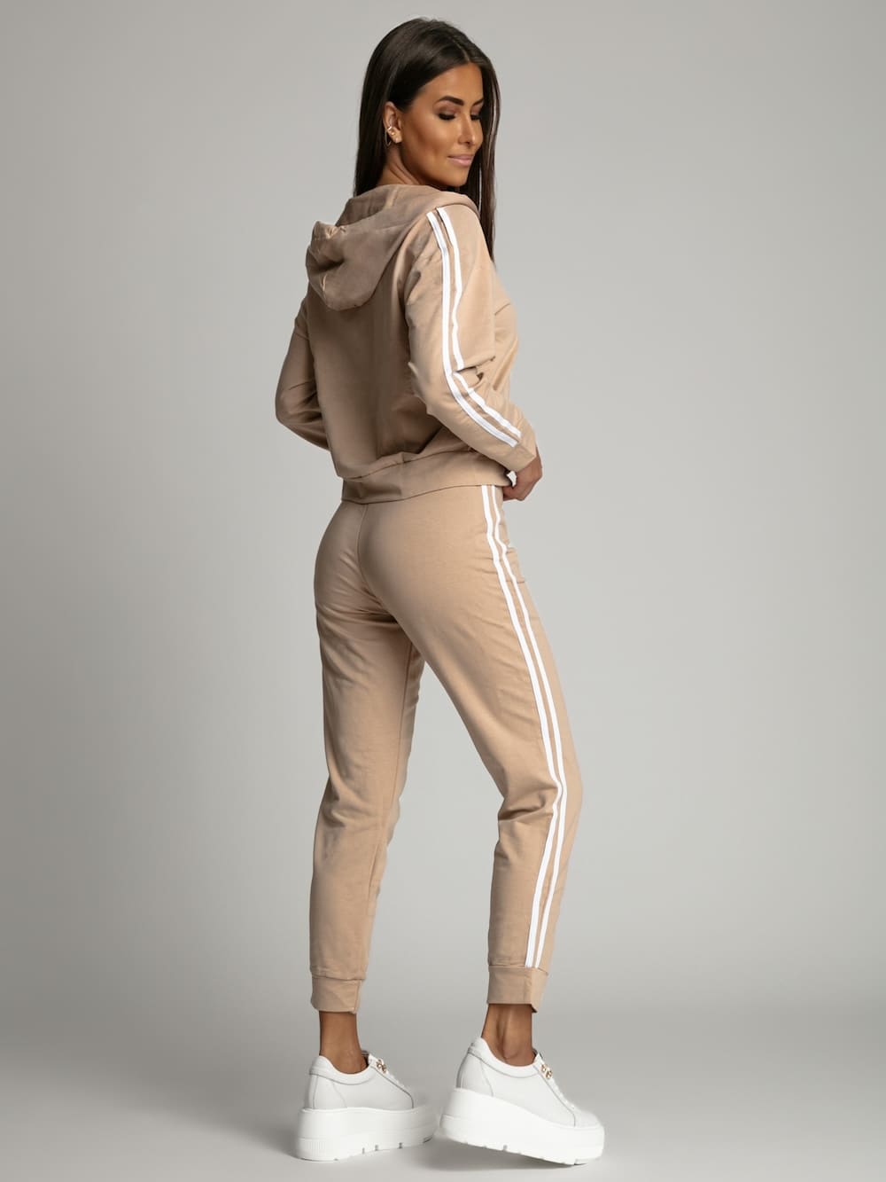 Women's beige tracksuit set featuring a zip-up hoodie and elastic waist pants with white stripes, perfect for casual and sporty looks.