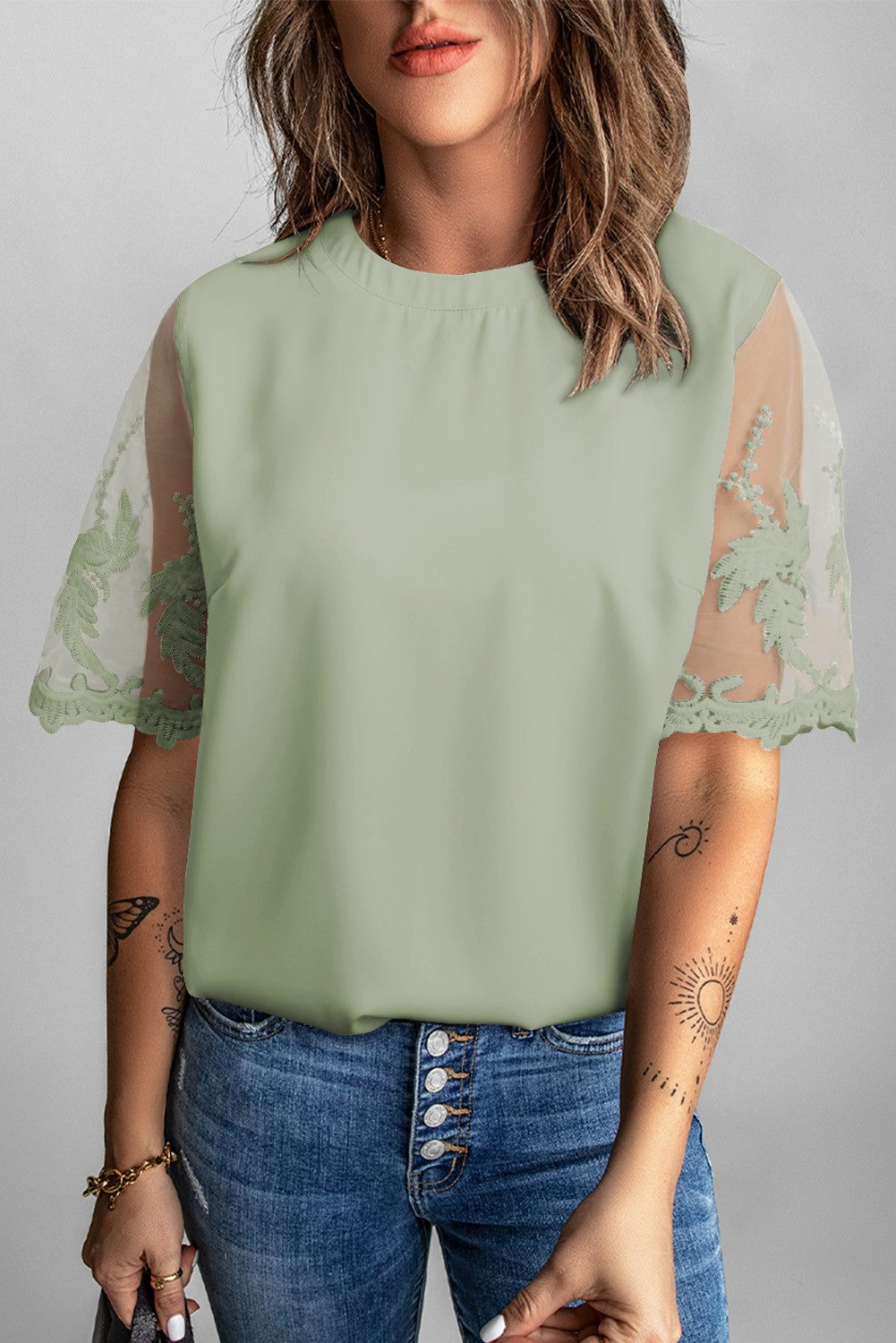 Women's green T-shirt with transparent lace sleeves, featuring a round collar and loose fit, perfect for elegant and casual wear.