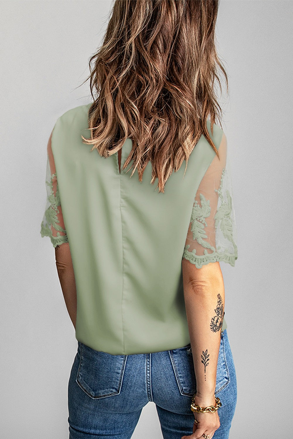 Women's green T-shirt with transparent lace sleeves, featuring a round collar and loose fit, perfect for elegant and casual wear.