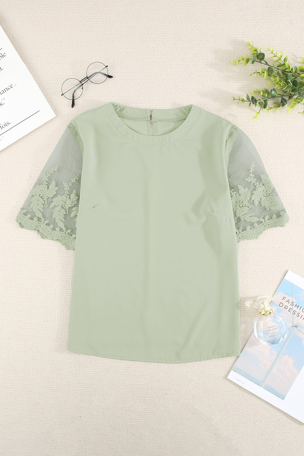 Women's green T-shirt with transparent lace sleeves, featuring a round collar and loose fit, perfect for elegant and casual wear.