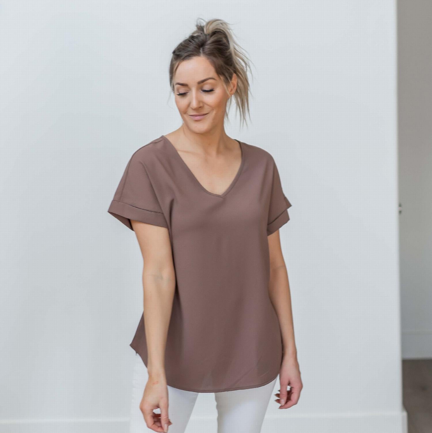 Woven Heavy Dobby Rolled Sleeve V-neck Top in bright pink, showcasing its loose fit and rolled sleeves.