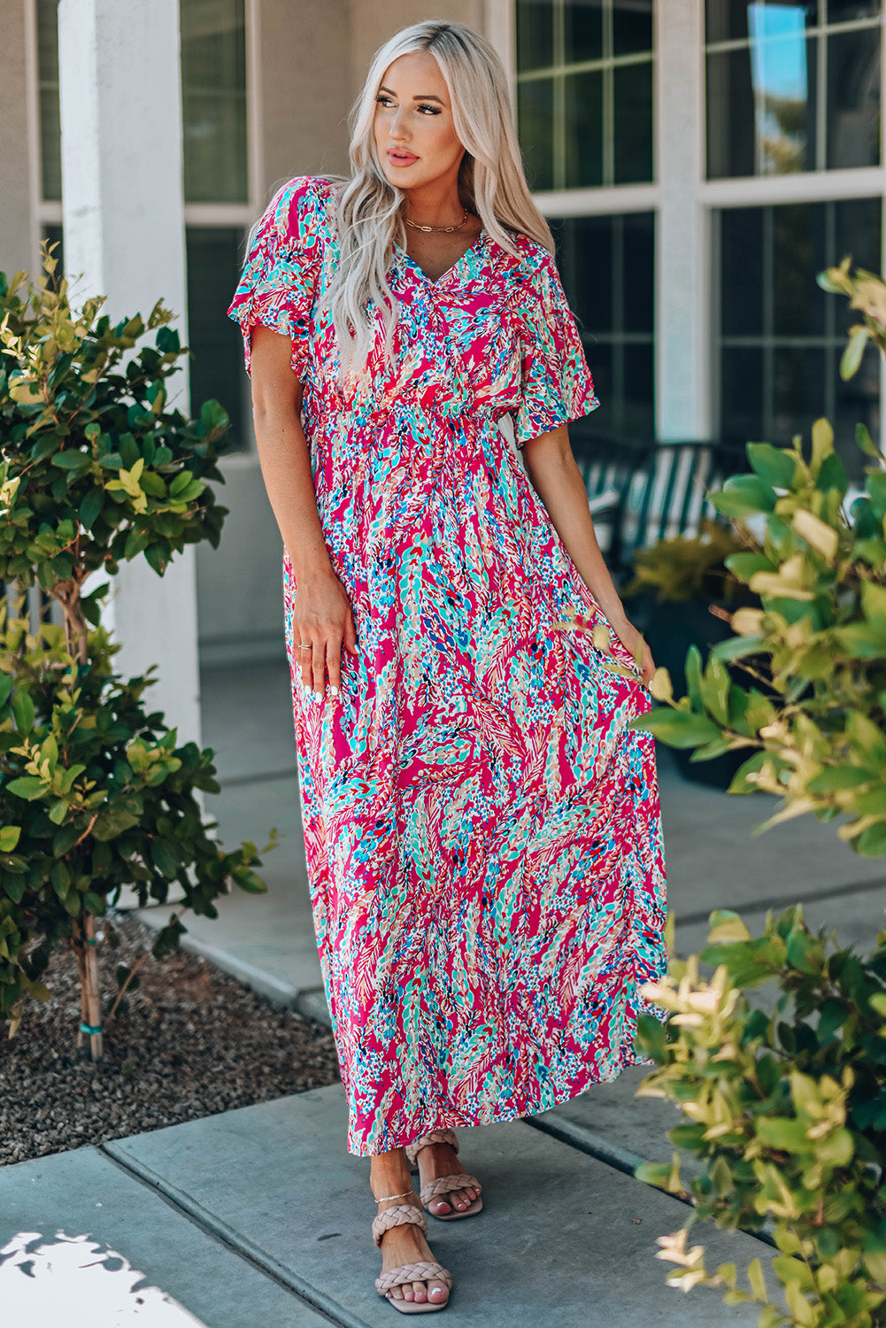 A beautiful woman wearing a Wrap V Neck Floral Maxi Dress with a vibrant floral print, flutter sleeves, and a flattering silhouette, perfect for summer occasions.