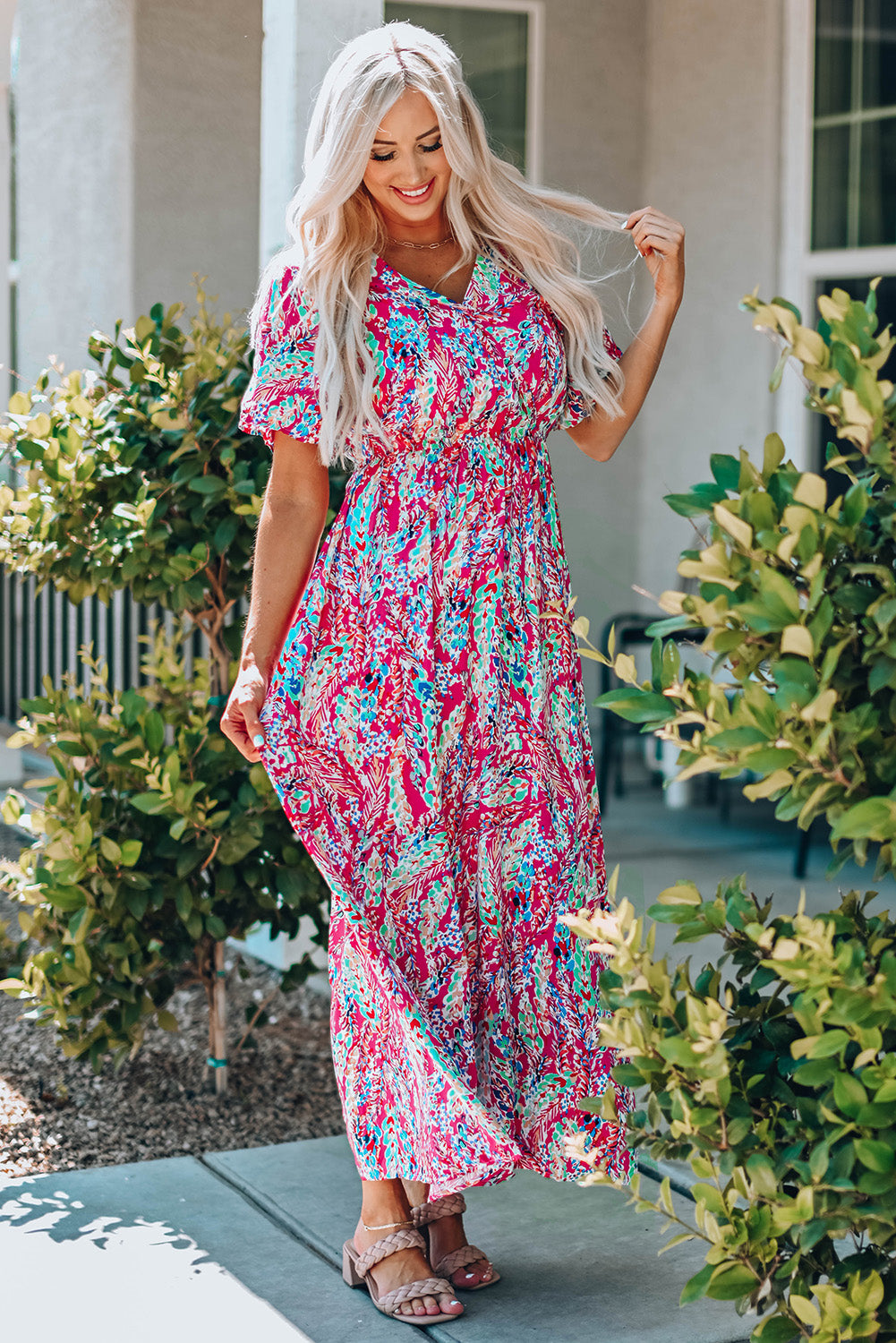 A beautiful woman wearing a Wrap V Neck Floral Maxi Dress with a vibrant floral print, flutter sleeves, and a flattering silhouette, perfect for summer occasions.