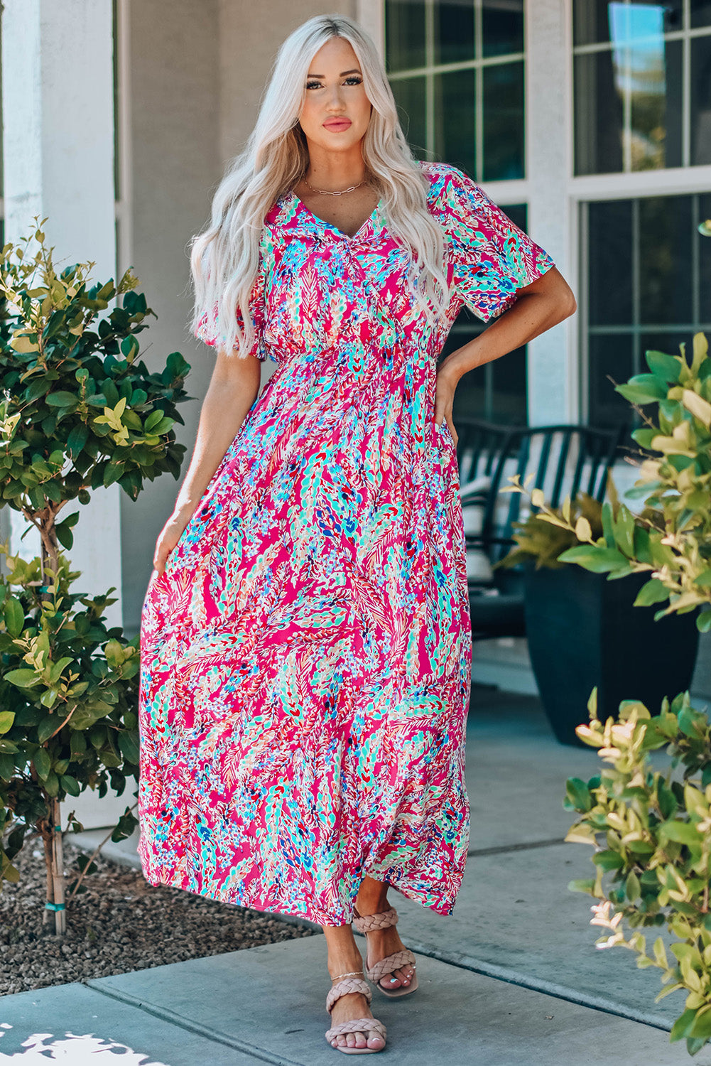 A beautiful woman wearing a Wrap V Neck Floral Maxi Dress with a vibrant floral print, flutter sleeves, and a flattering silhouette, perfect for summer occasions.