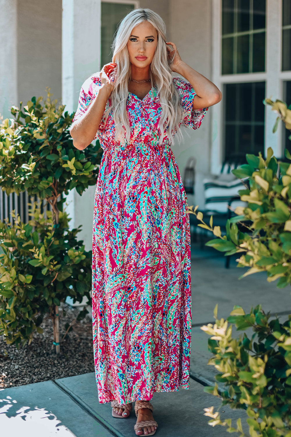 A beautiful woman wearing a Wrap V Neck Floral Maxi Dress with a vibrant floral print, flutter sleeves, and a flattering silhouette, perfect for summer occasions.